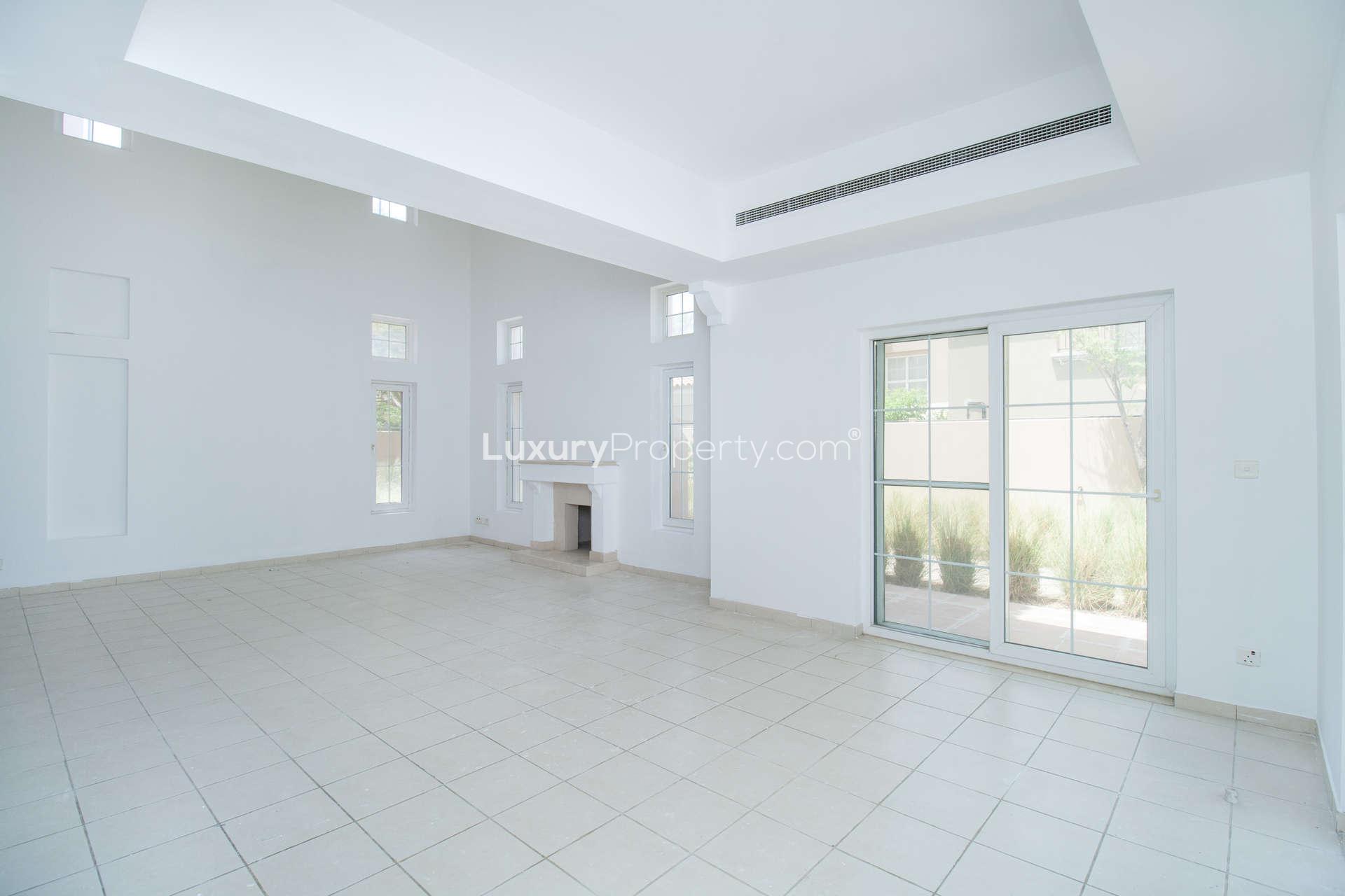 Spacious living room in Type 17 Villa, Mirador, Arabian Ranches with fireplace and large windows