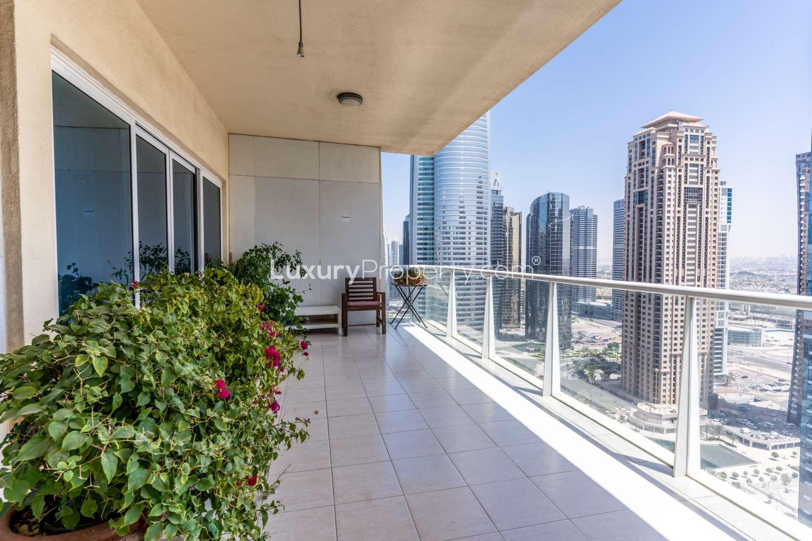 Modern bathroom in JLT Lake View apartment, featuring bathtub, sink, and washing machine