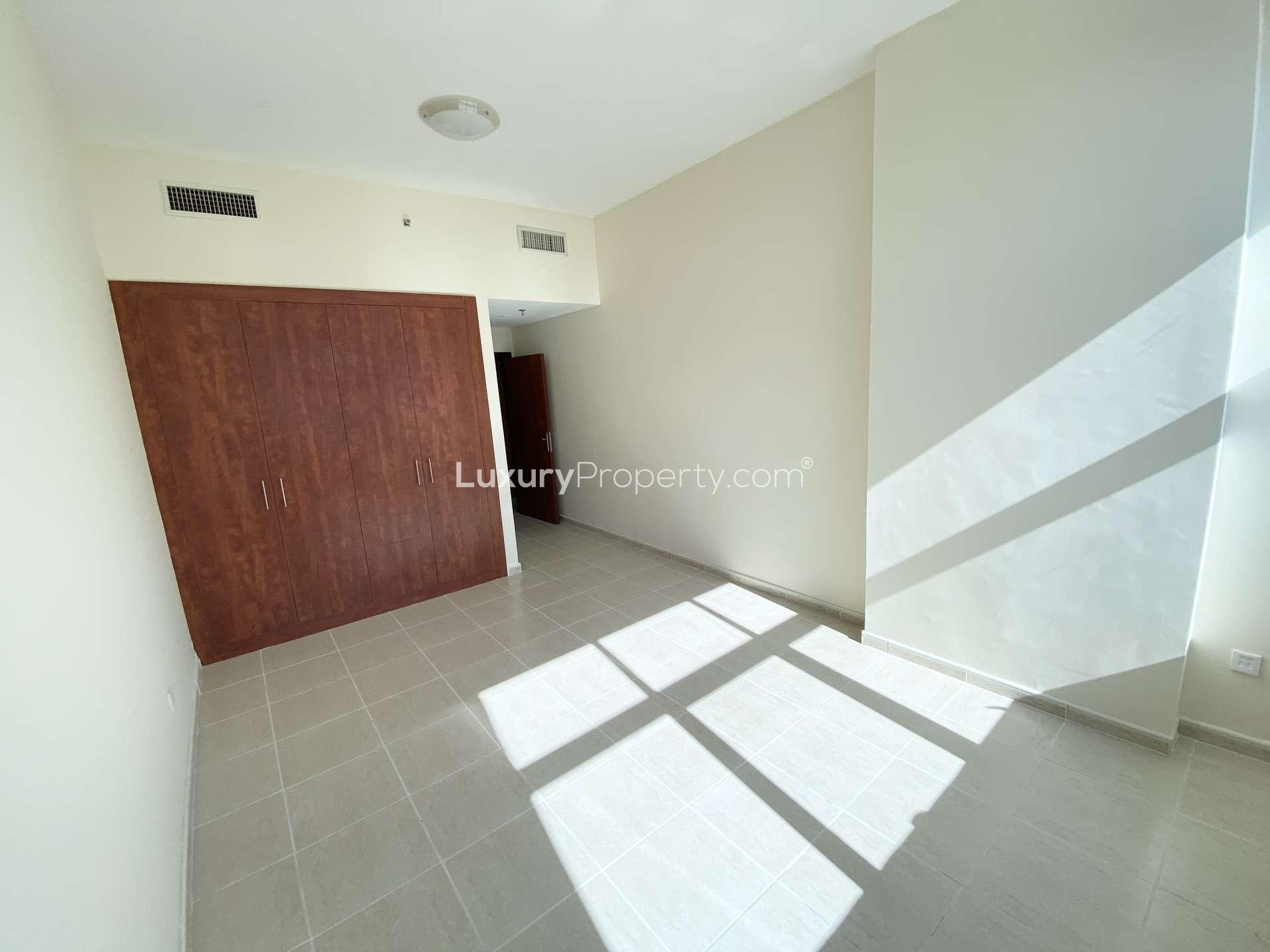 Bright living room with large windows in Olympic Tower 2 apartment, Dubai Sports City
