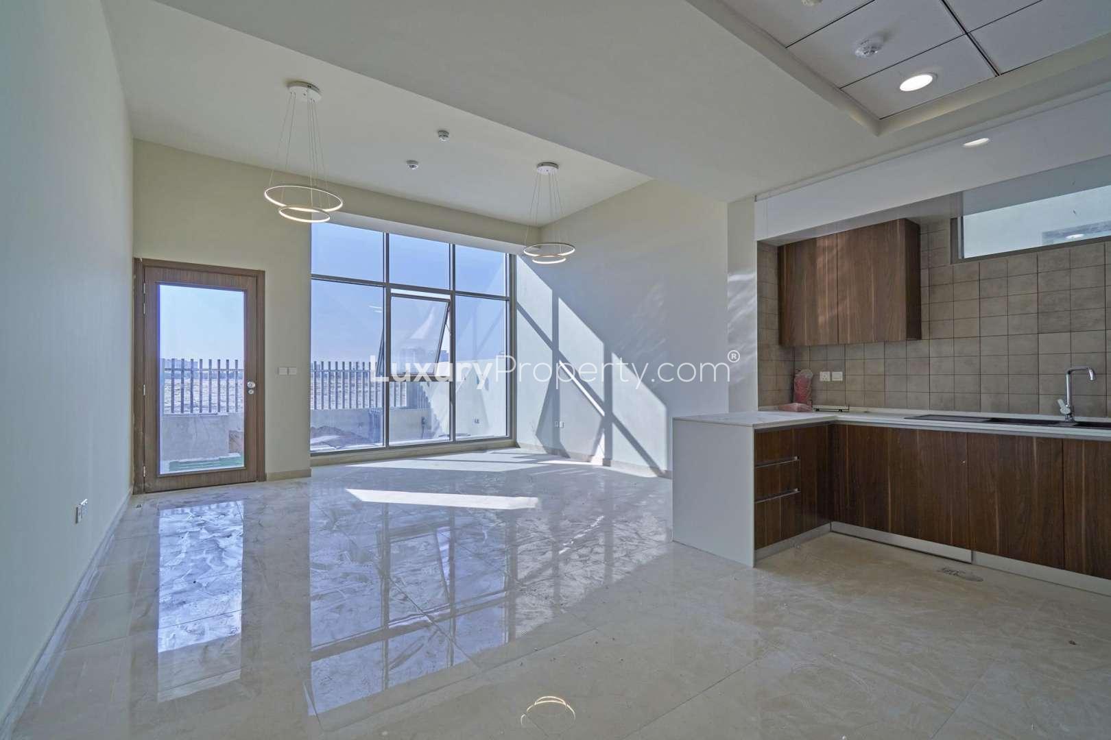 Empty room with wooden flooring and large window in Al Furjan townhouse, Murano Residences