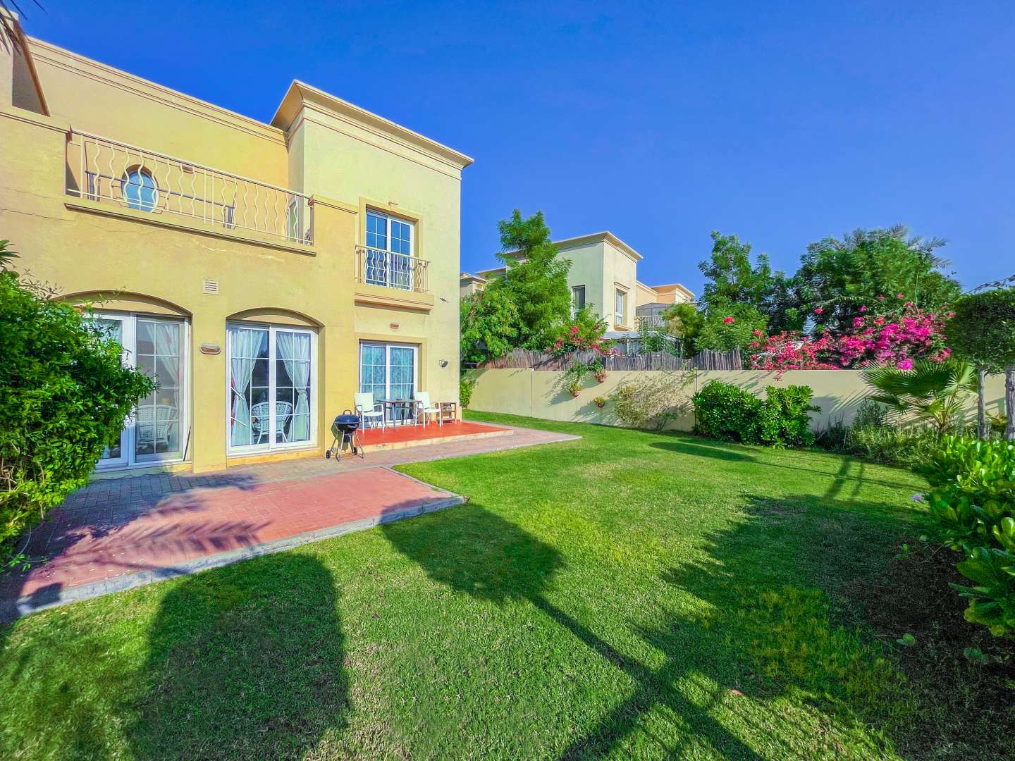 "Interior of three-bed villa in The Springs with modern decor and cozy seating area.",Three-bed villa exterior with lush garden in The Springs, Dubai, for sale