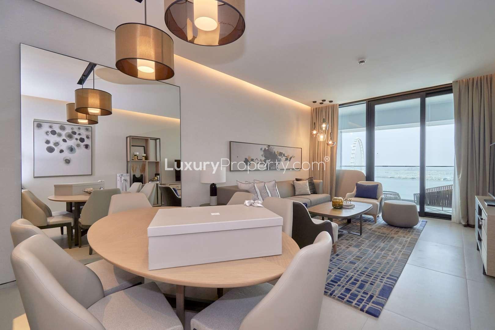 Fully furnished living room in 3-bedroom Jumeirah Beach apartment, modern decor, open kitchen layout