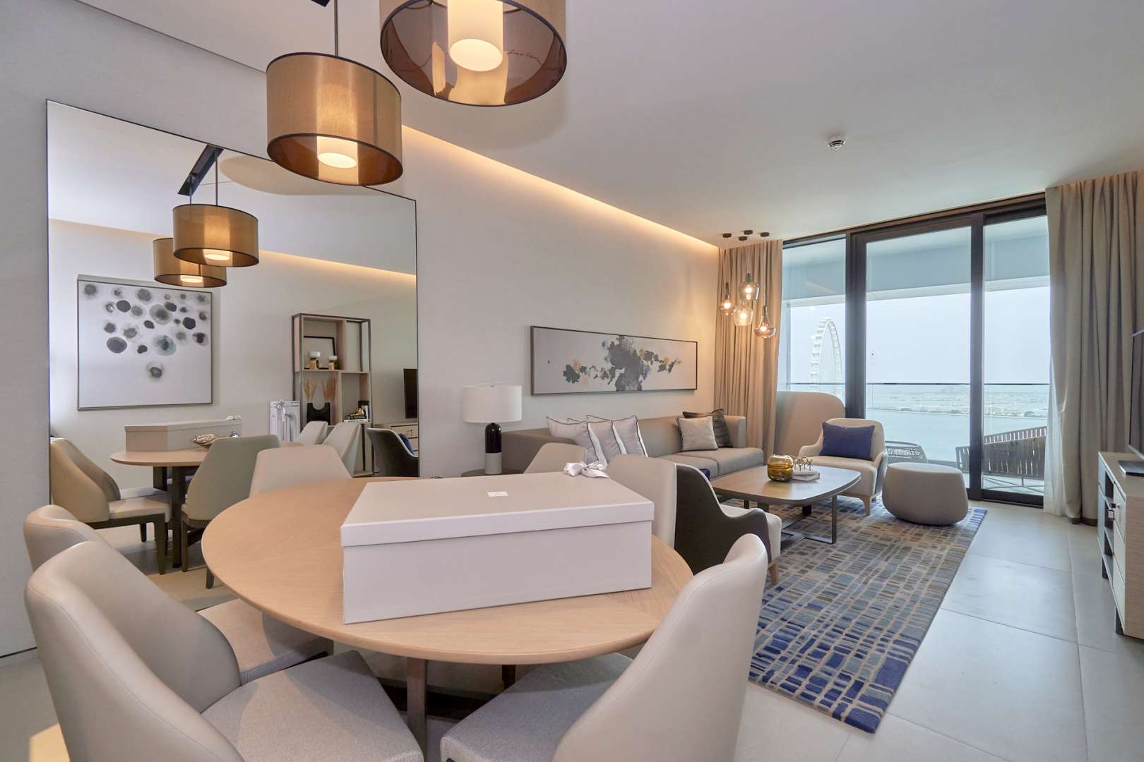 Fully furnished living room in 3-bedroom Jumeirah Beach apartment, modern decor, open kitchen layout