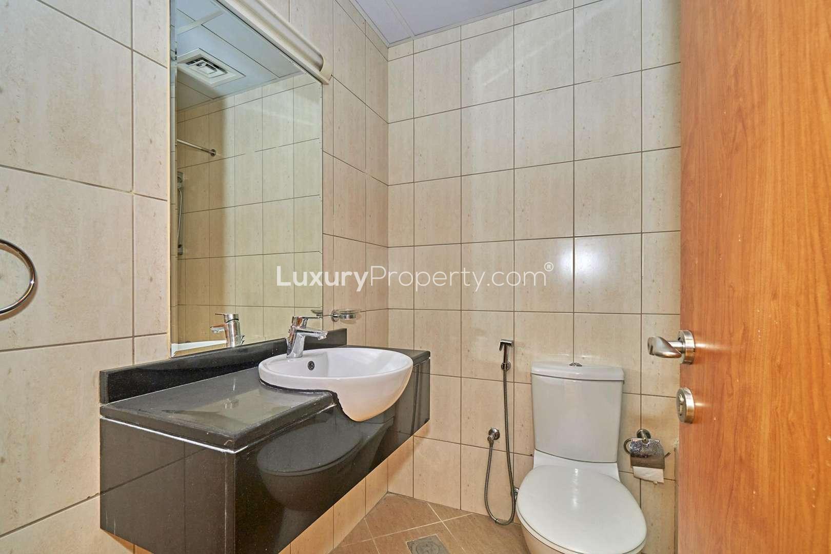 Empty room with tiled floor and large window in Emirates Garden apartment, JVC