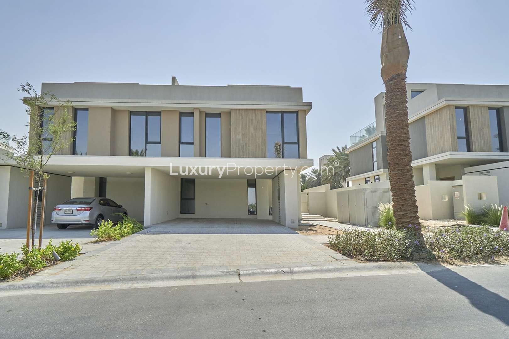 Modern open-plan living area in Dubai Hills Estate townhouse with large windows and garden view