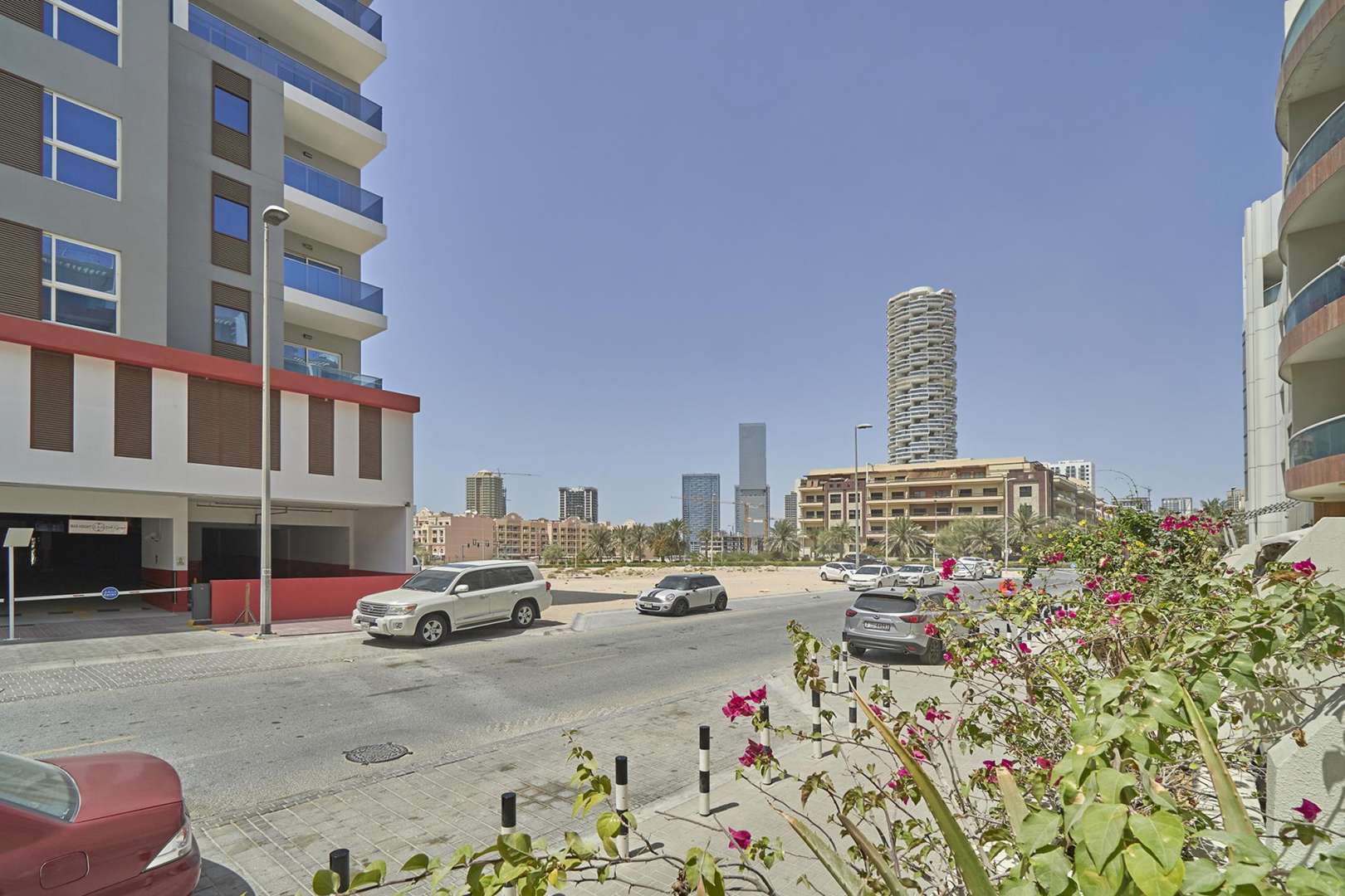 Studio apartment interior with bed, sofa, and balcony view in Knightsbridge Court, JVC