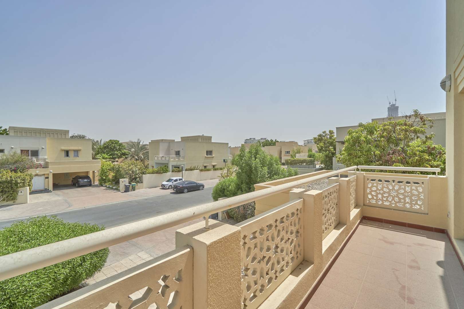 "Spacious balcony view from exclusive 4-bedroom villa for sale in Meadows 2 community.",Empty room with chandelier in vacant 4-bedroom villa, Meadows 2, for sale