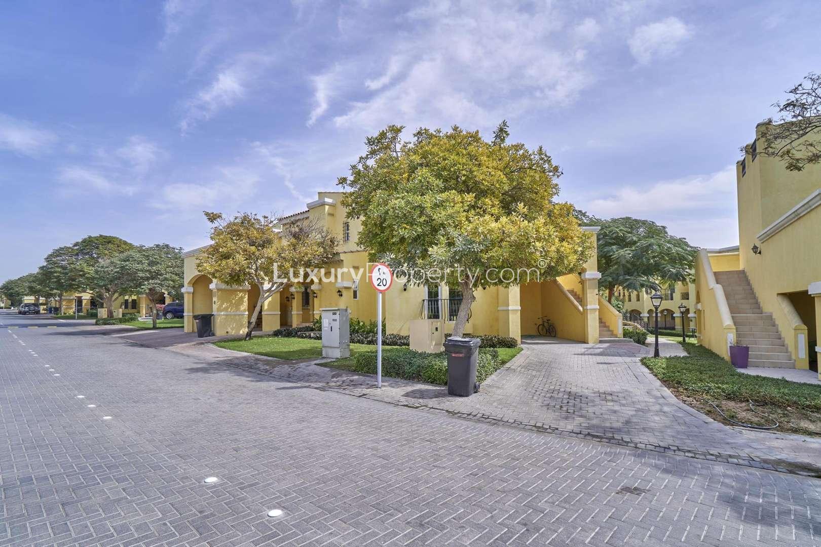 Exterior view of 2-bedroom townhouse in Layan Community, Dubai, with garden and driveway