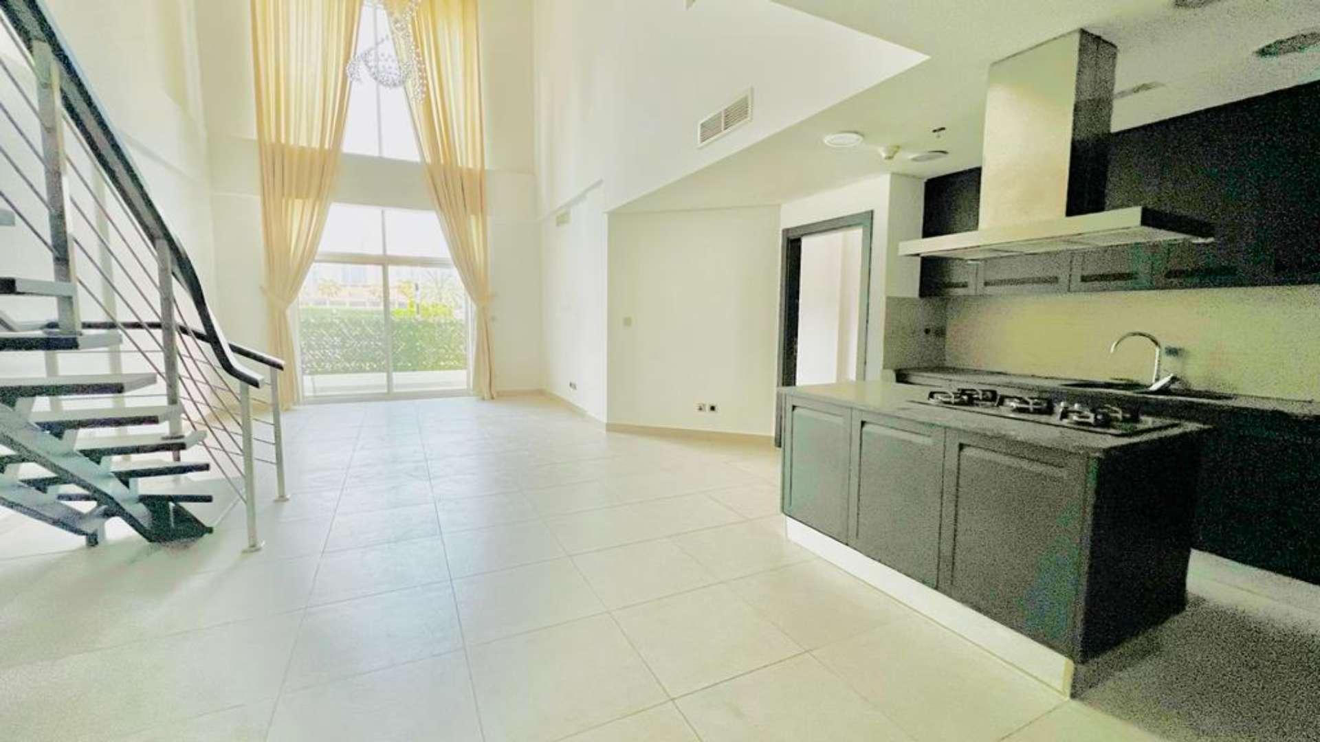 "Modern apartment building in Jumeirah Heights, Cluster E, available for rent, exterior view.",Modern open-plan kitchen and living area in Jumeirah Heights duplex apartment for rent