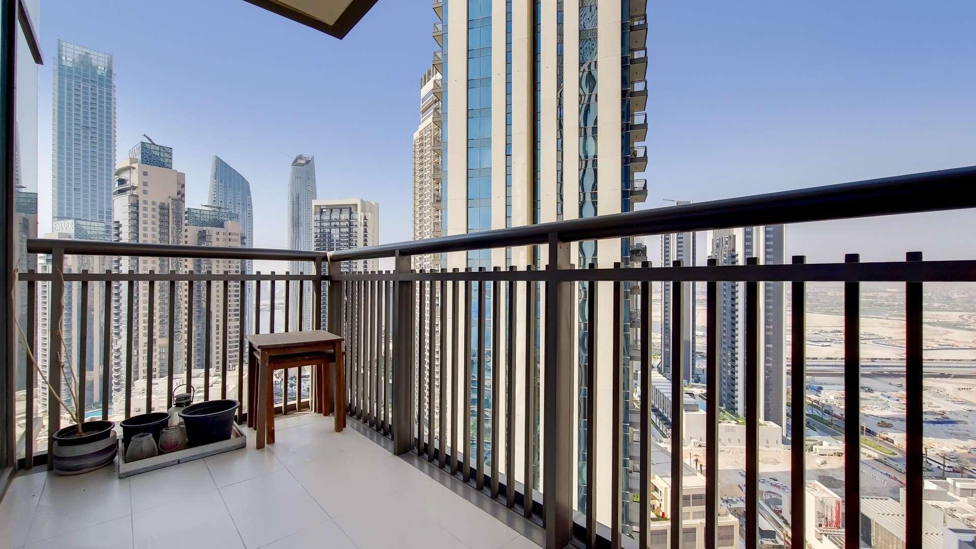 Modern mid-floor apartment living area with open kitchen in Creekside 18, available for rent