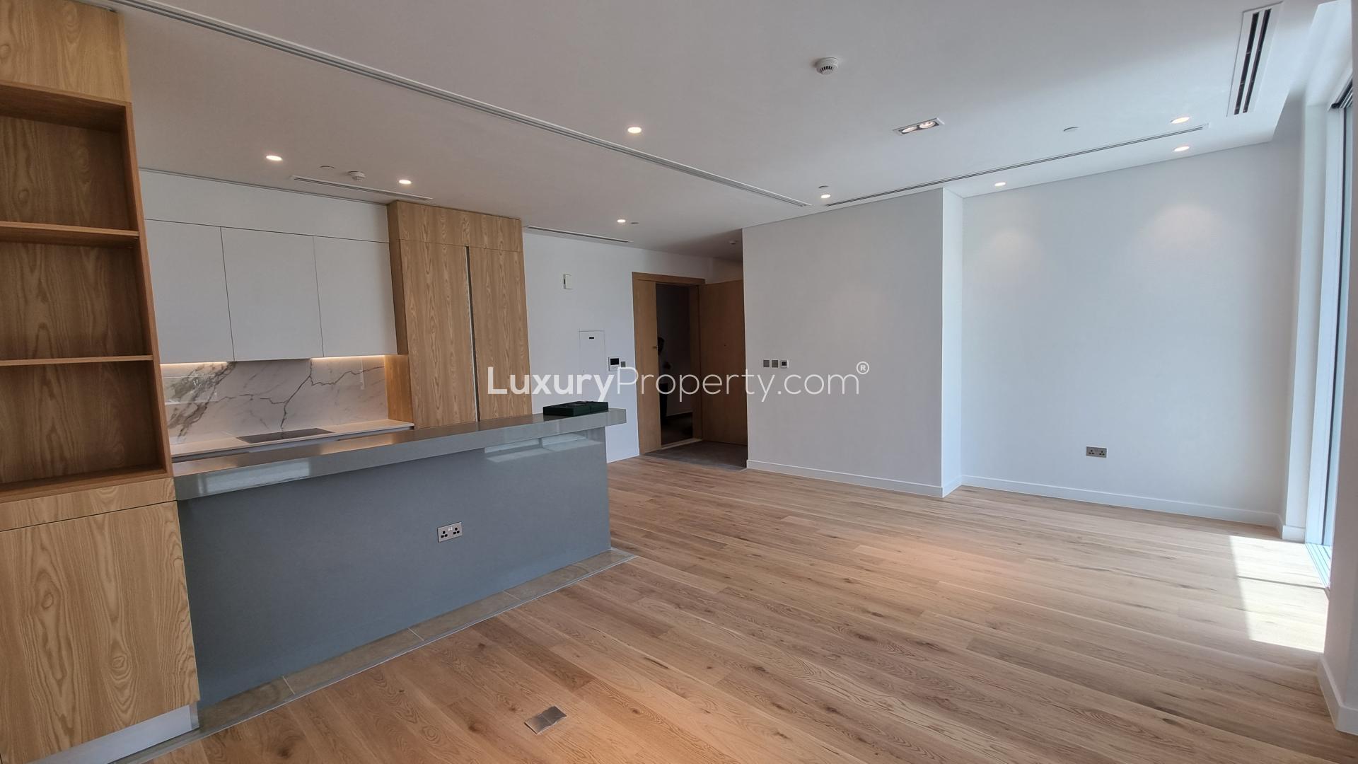 Modern kitchen and living area in Al Barari 1-bedroom apartment for sale