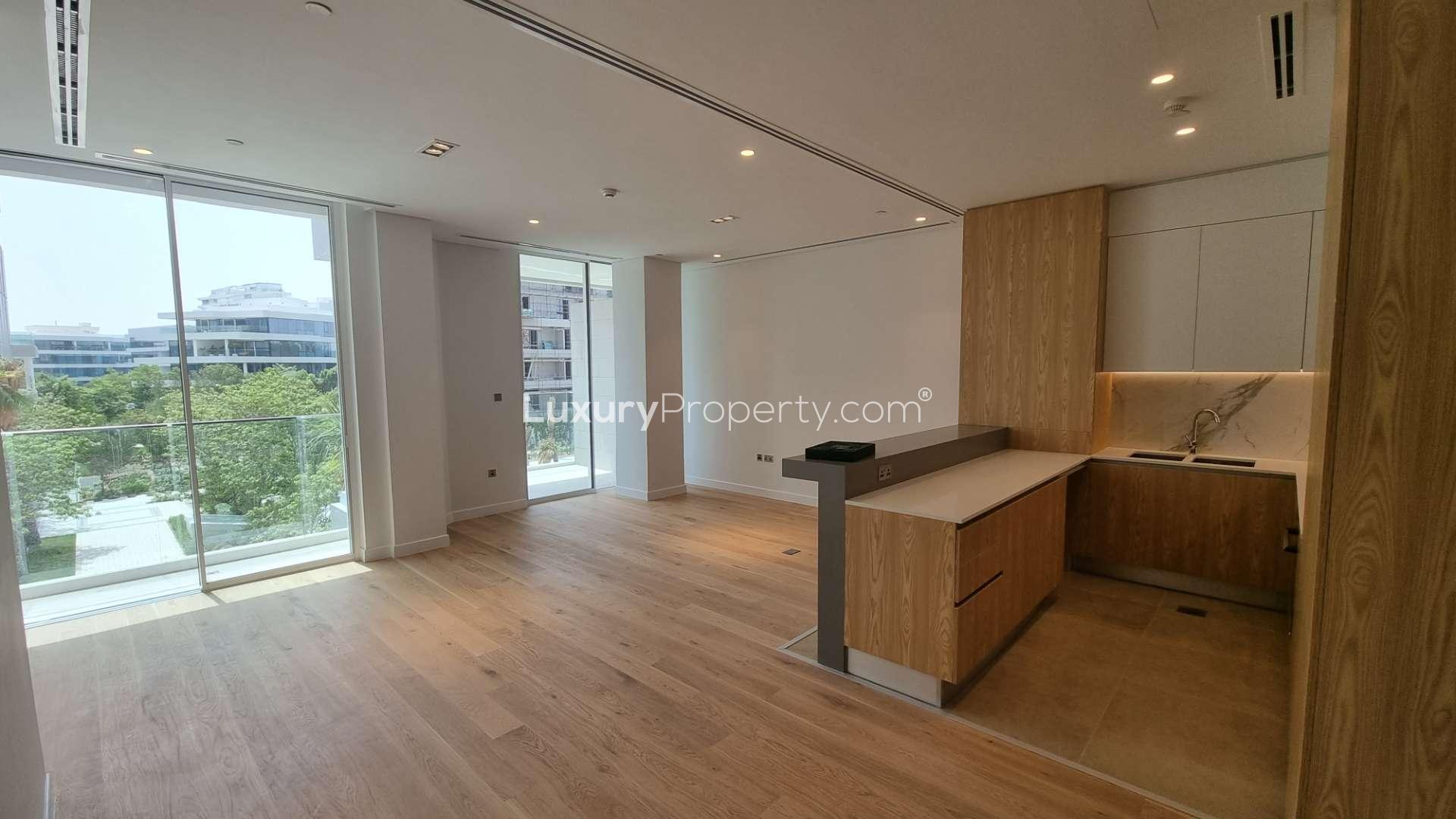 Stylish open-plan kitchen and living area in 1-bedroom Al Barari apartment with pool view