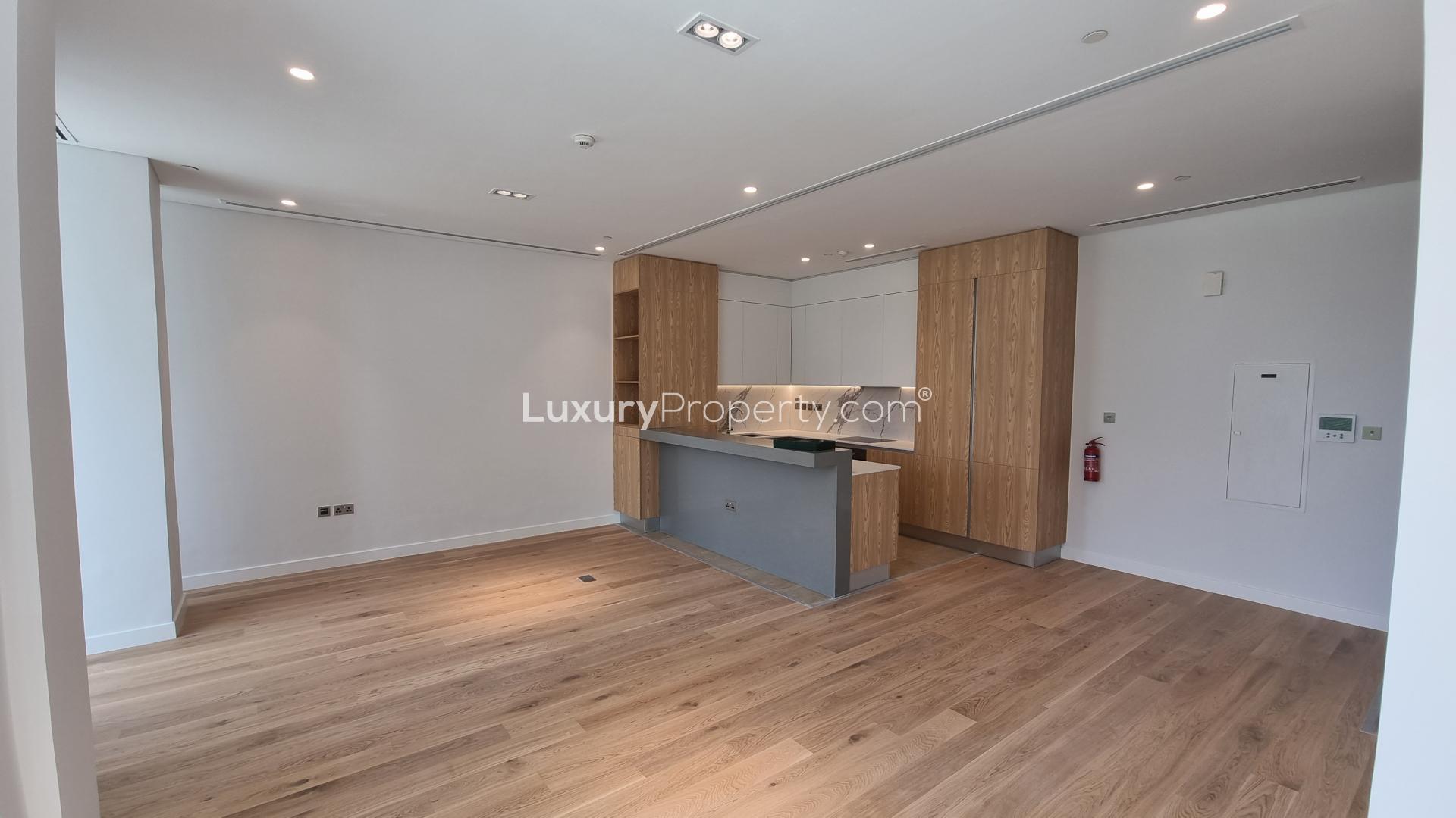 Modern kitchen and living area in Al Barari 1-bedroom apartment for sale