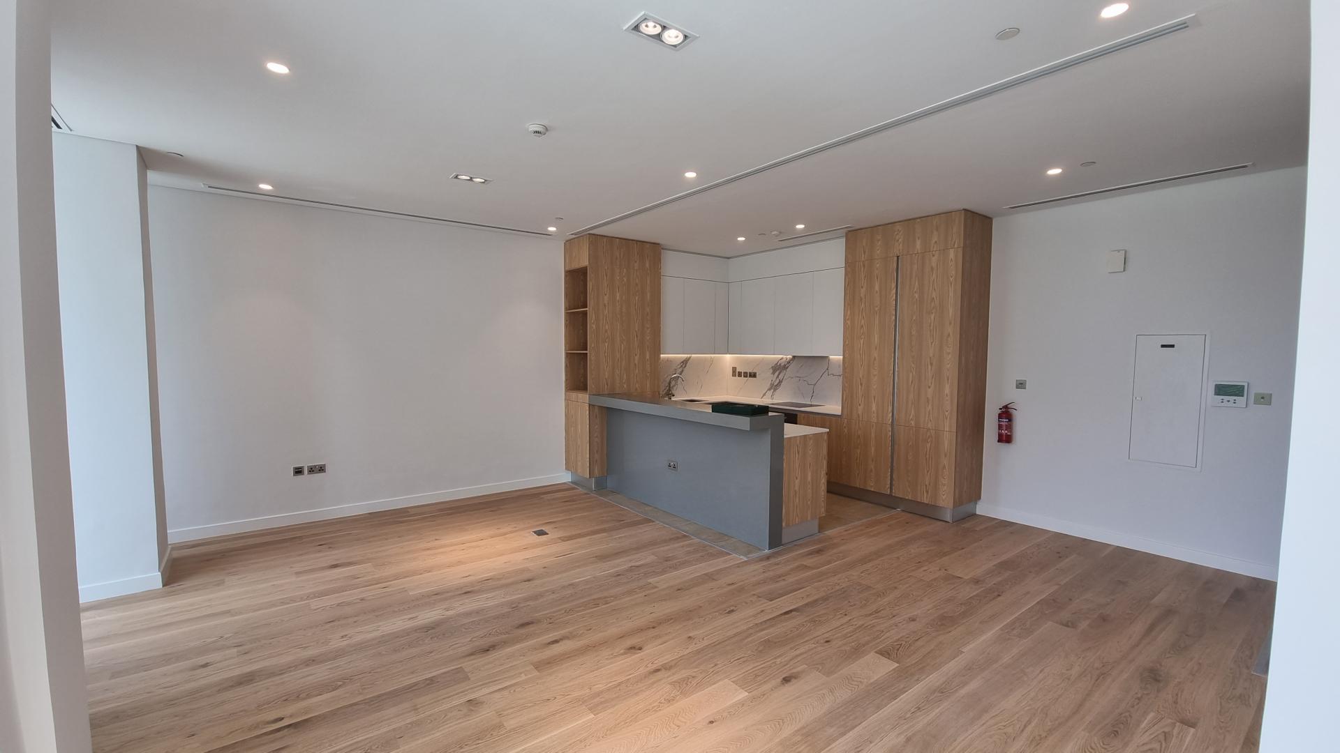 Modern kitchen and living area in Al Barari 1-bedroom apartment for sale