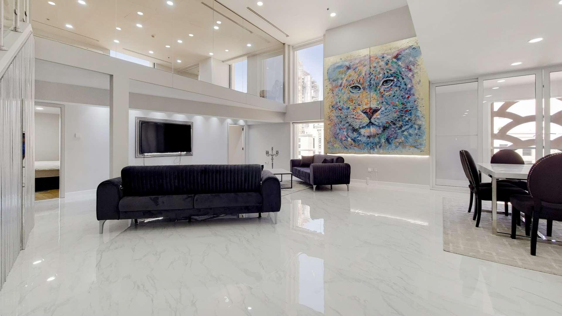 "Spacious designer loft living area in Jumeirah Beach Residence, Sadaf community, featuring modern furnishings.",Spacious designer loft in JBR Sadaf with modern furnishings and vibrant lion artwork