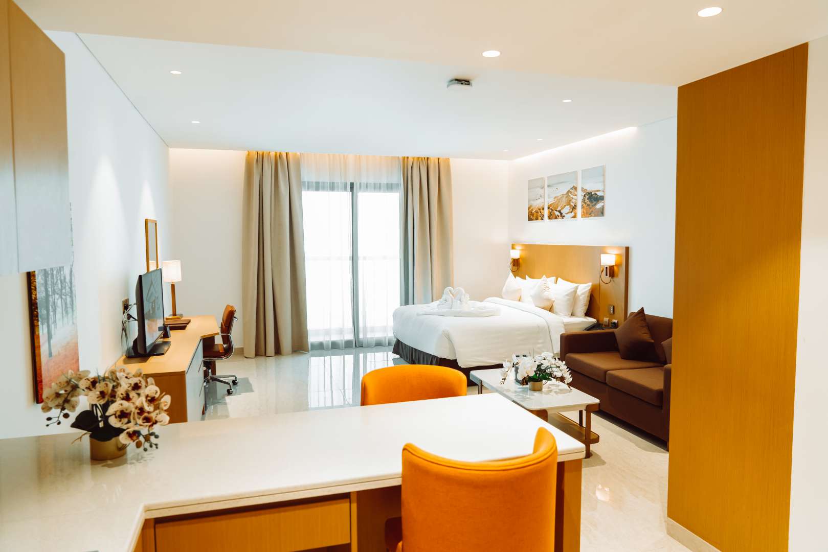 Studio apartment interior with twin beds in deluxe hotel, natural light from large window