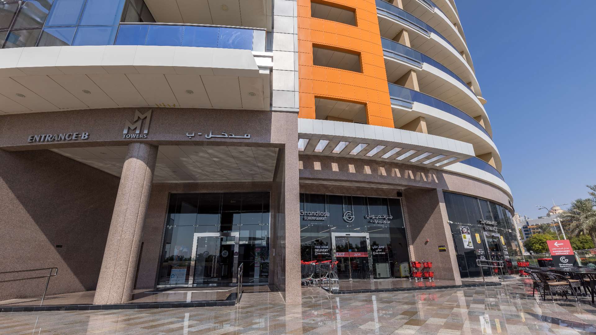 Twin-tower apartment building in Dubai Silicon Oasis, MM Towers, lush greenery, blue sky