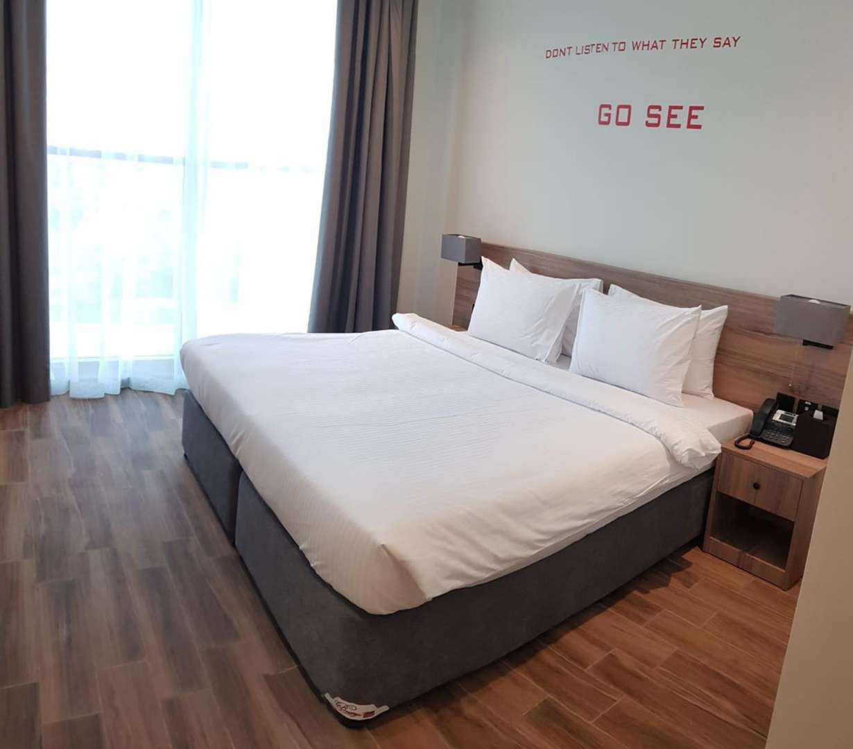 Studio room in four-star waterfront hotel with modern decor, flat-screen TV, and desk