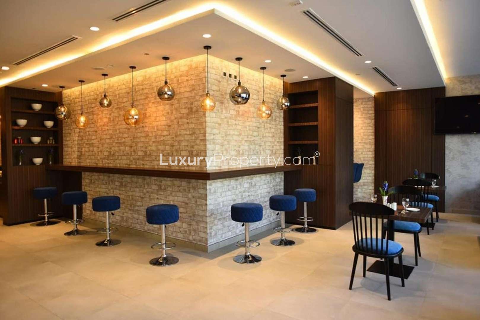 Contemporary hotel bar with modern seating, ideal investment opportunity in 3 Star community
