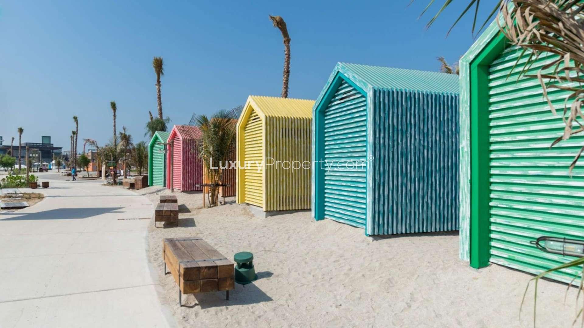 Beachfront view of La Mer Maisons, Jumeirah; serene turquoise waters and sandy shoreline