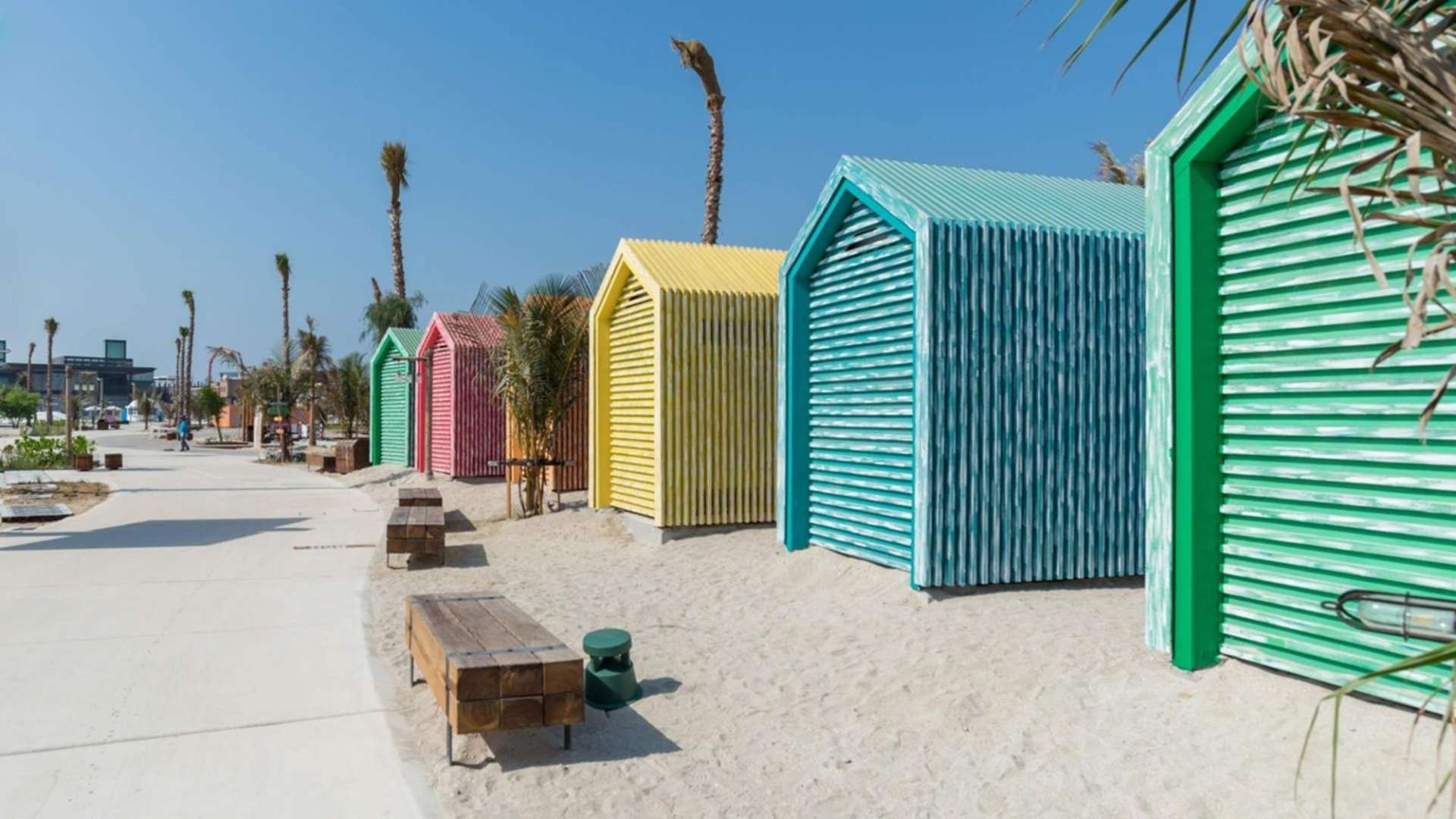 Beachfront view of La Mer Maisons, Jumeirah; serene turquoise waters and sandy shoreline