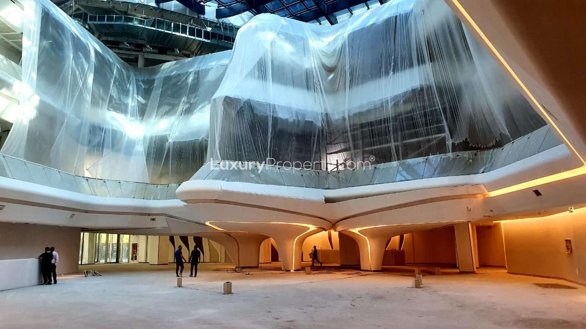 Spacious retail space with modern glass architecture in The Opus, Business Bay, Dubai