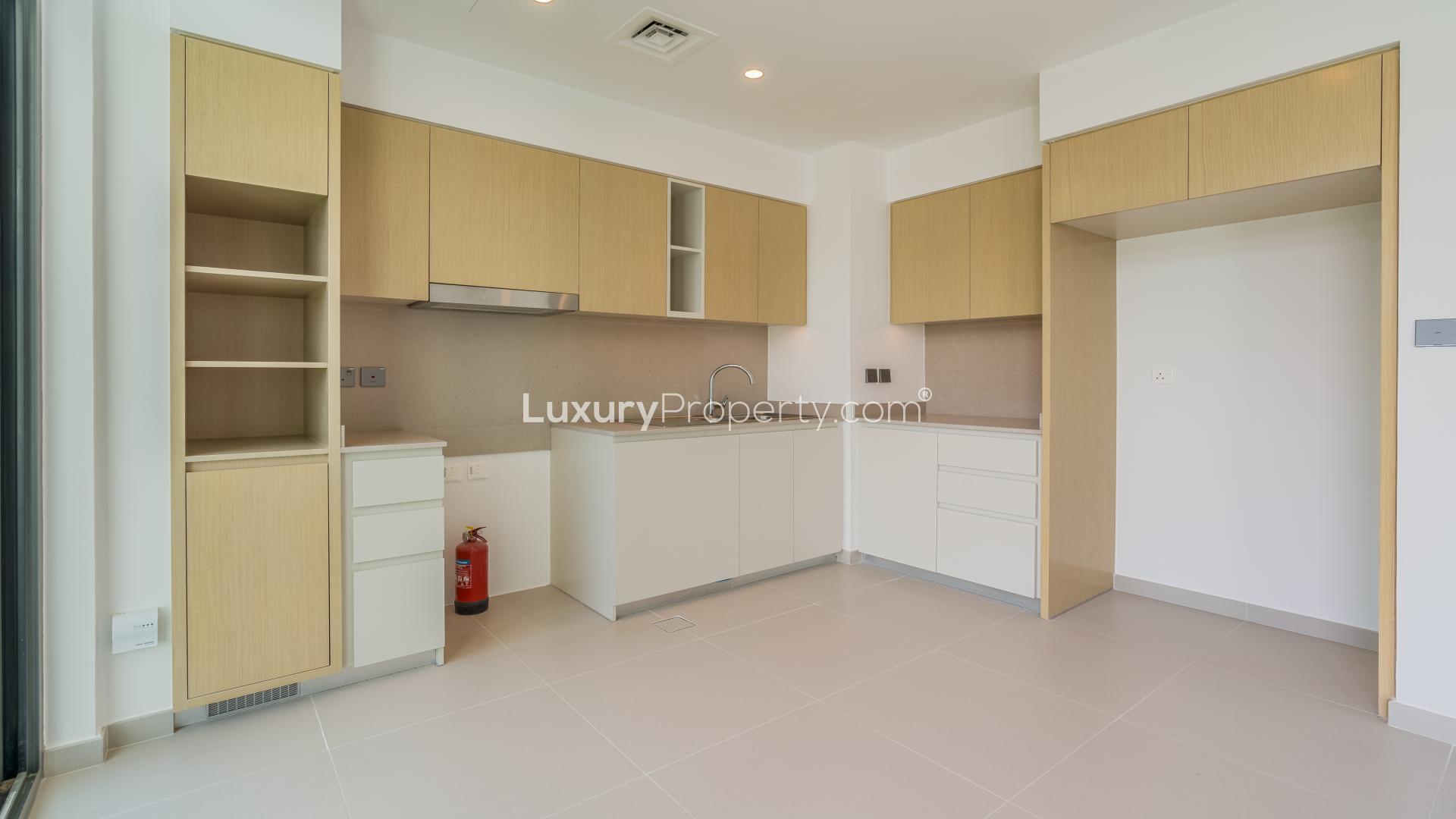 Spacious kitchen and living area in Joy townhouse, Arabian Ranches III, with garden view