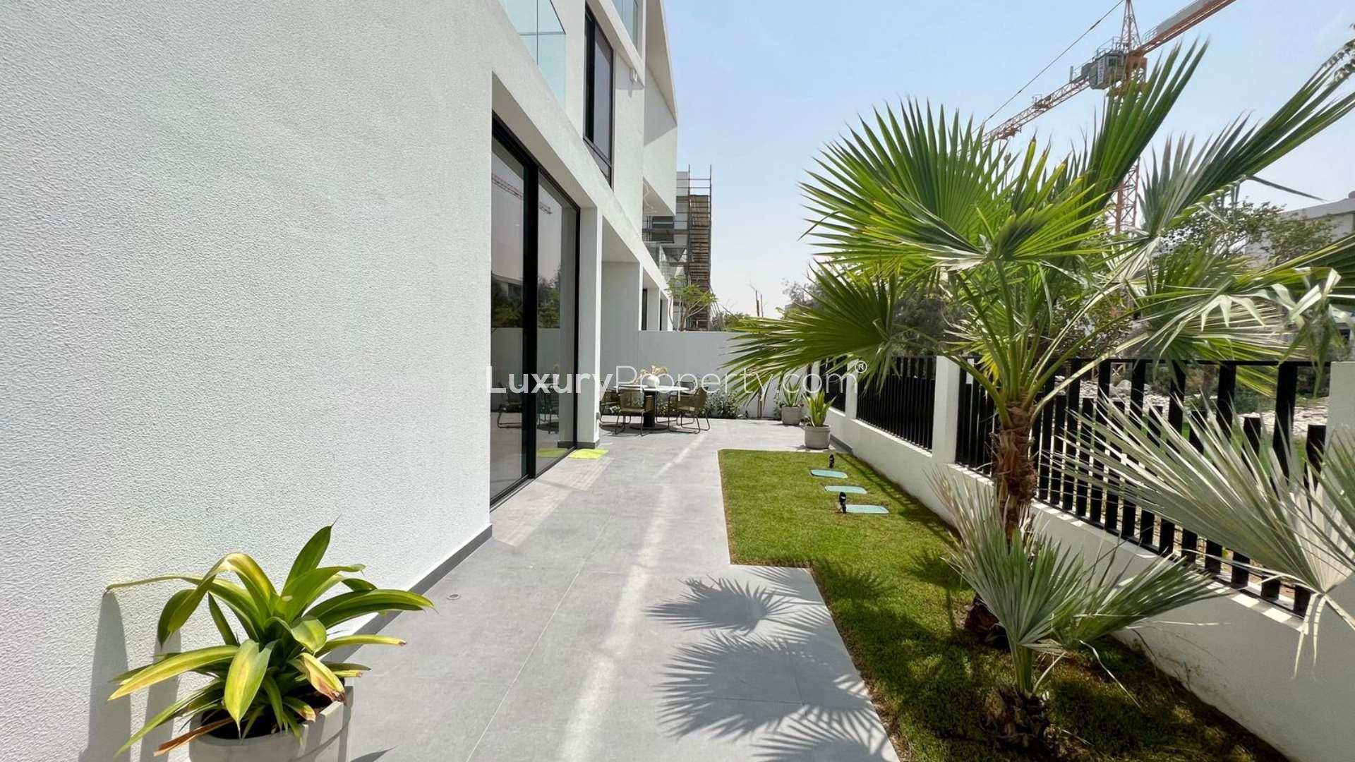 Luxurious living room in Chorisia 1 Villa, Al Barari, with modern decor and glass staircase