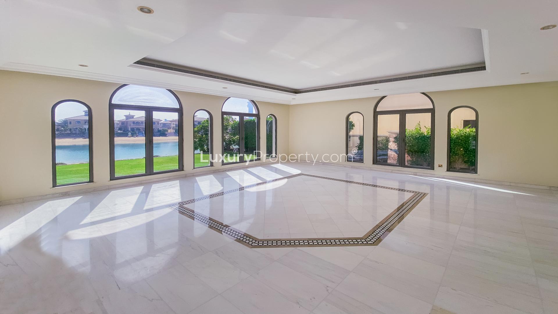 "Spacious villa terrace with stunning waterfront view at Palm Jumeirah Signature Villas.",Spacious living room with large windows overlooking water, Signature Villa, Palm Jumeirah