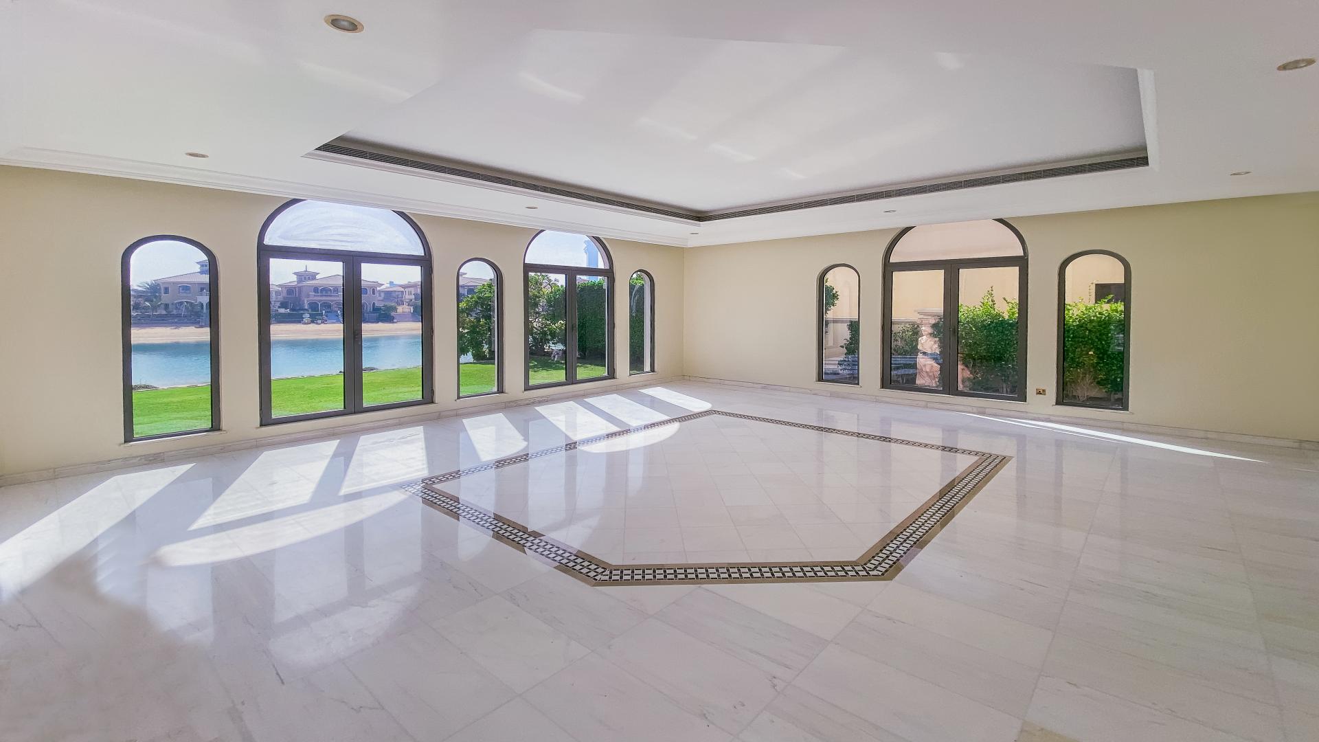 "Spacious villa terrace with stunning waterfront view at Palm Jumeirah Signature Villas.",Spacious living room with large windows overlooking water, Signature Villa, Palm Jumeirah