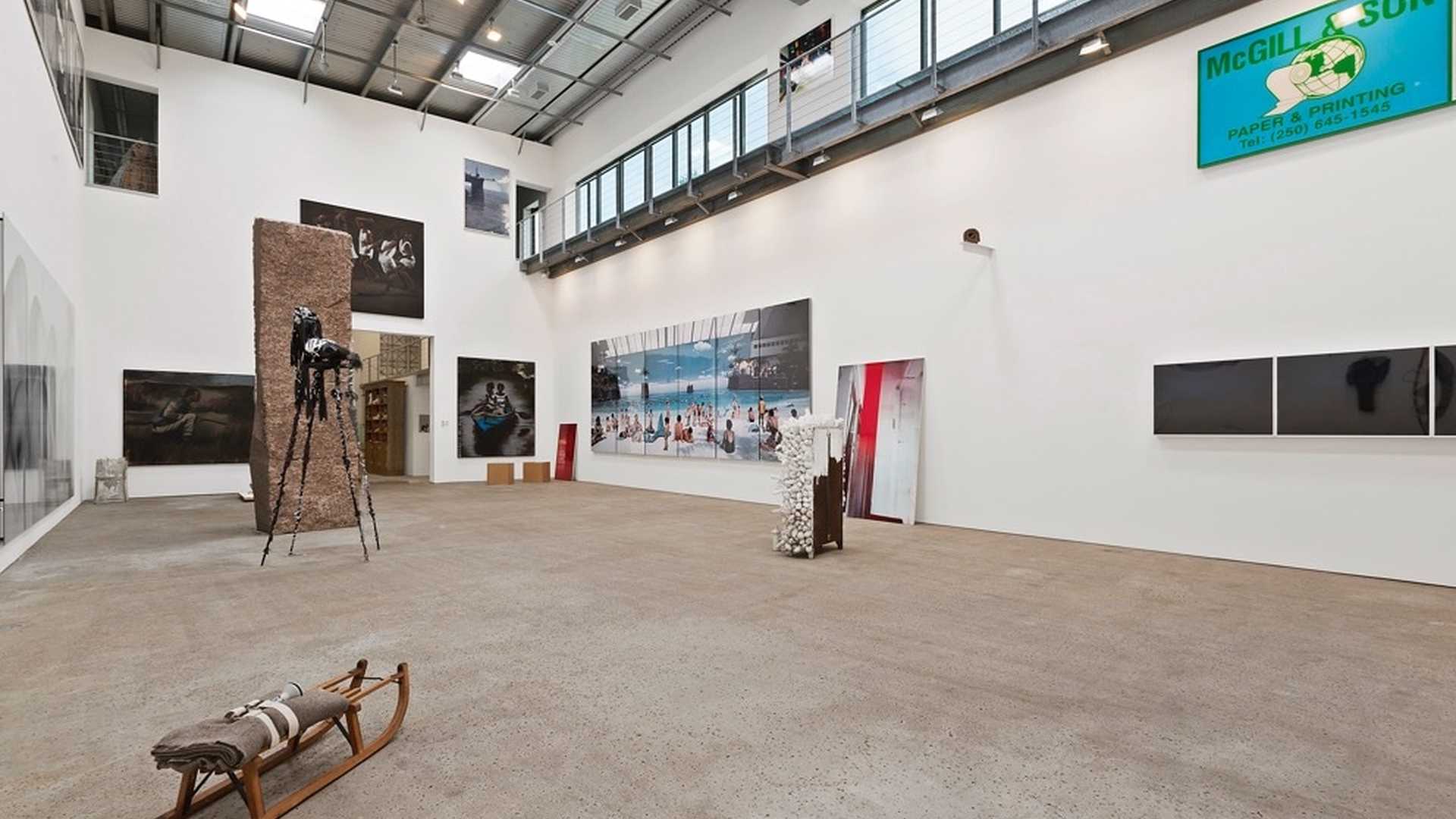 Art gallery interior in luxurious Southampton villa, featuring modern artwork and industrial design