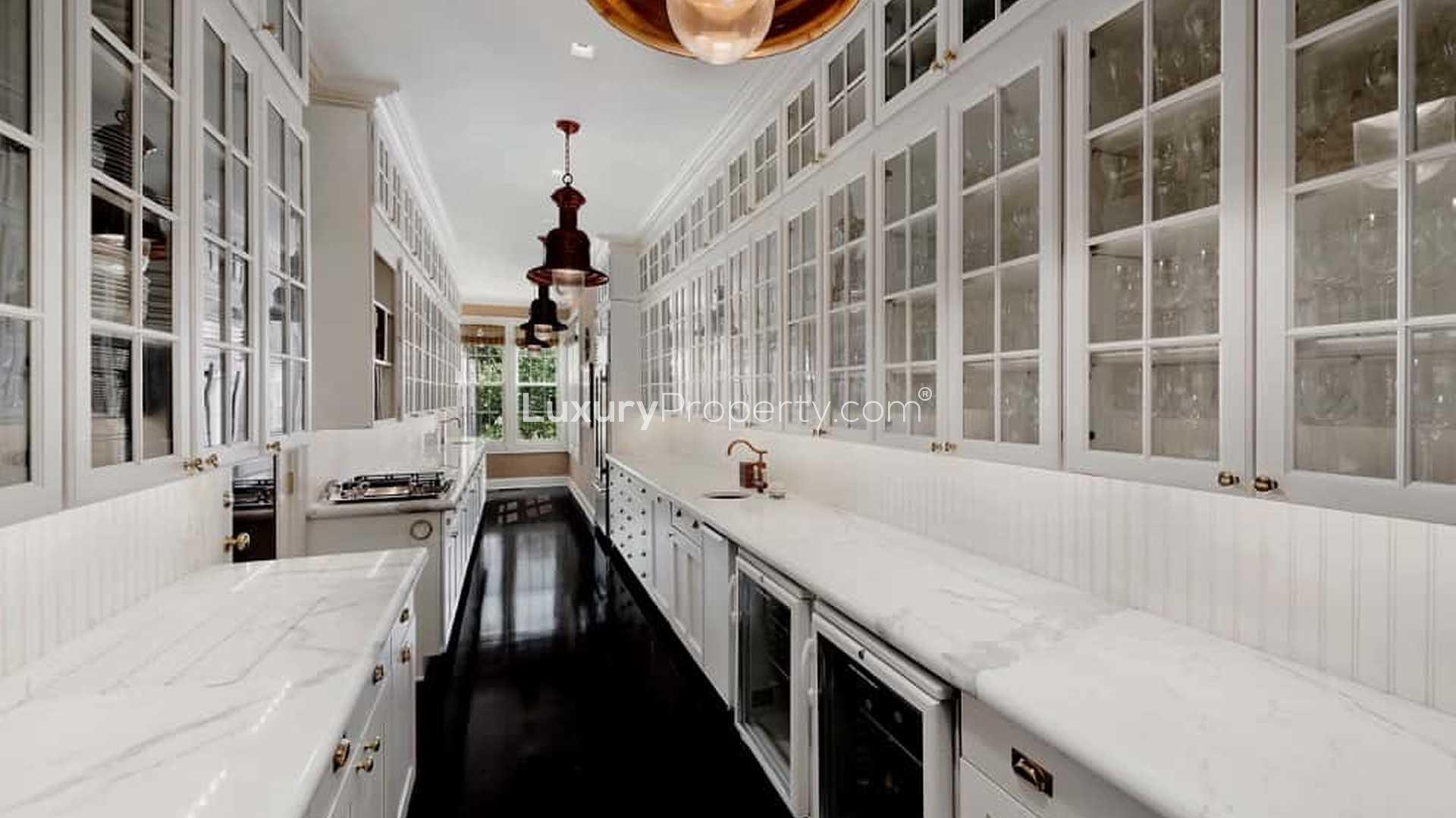 "Charming Dutch Colonial villa with pool, lush garden in Hamptons, New York for sale.",Luxurious kitchen in Dutch Colonial villa, marble countertops, glass cabinets, Hamptons, New York