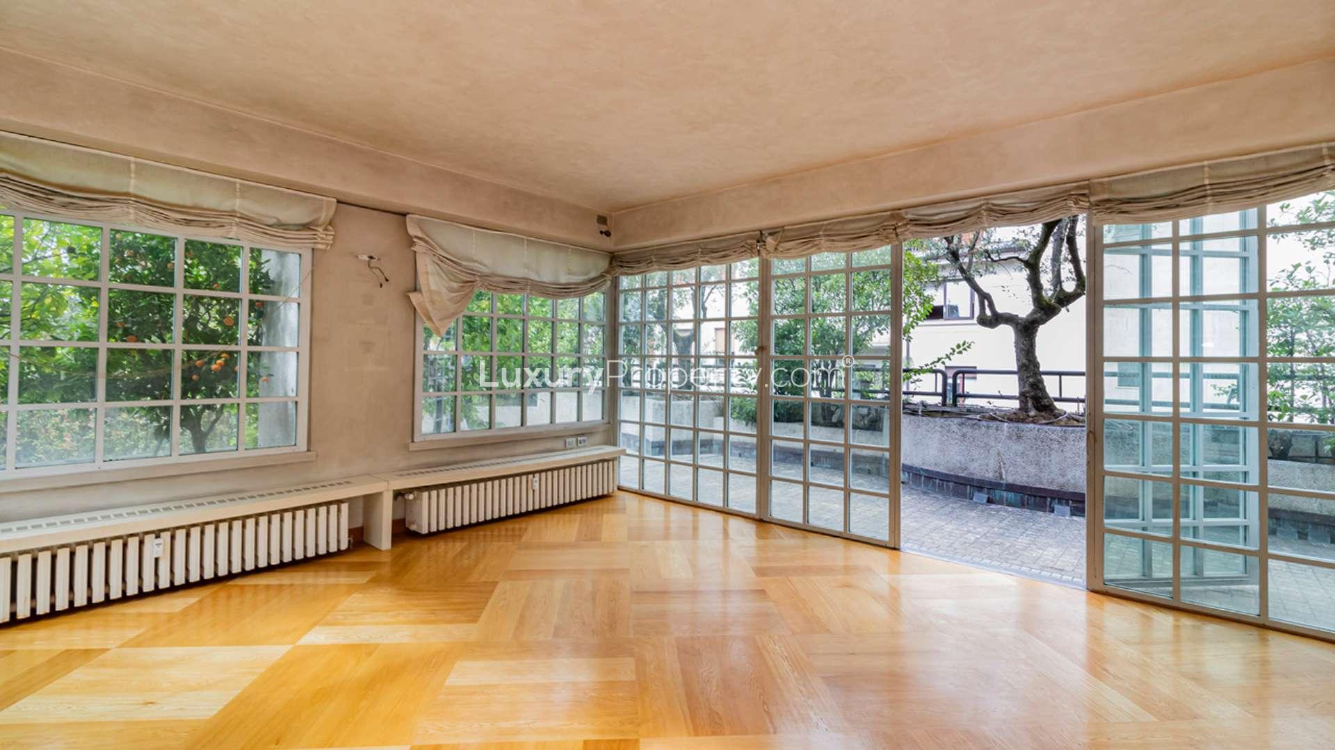 Elegant entrance of Via Serbelloni apartment, Milan, featuring marble floors and arched doors