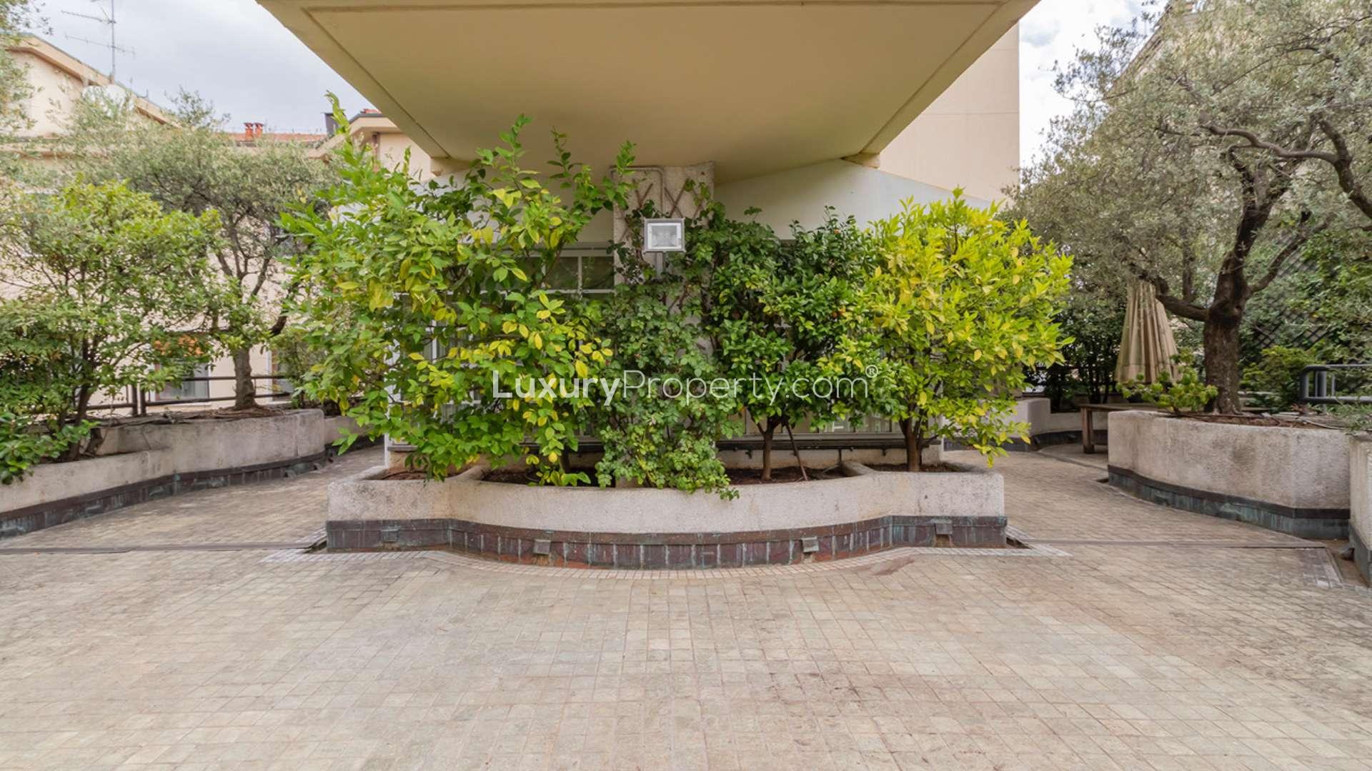 Spacious living room with large windows in Via Serbelloni apartment, Milan