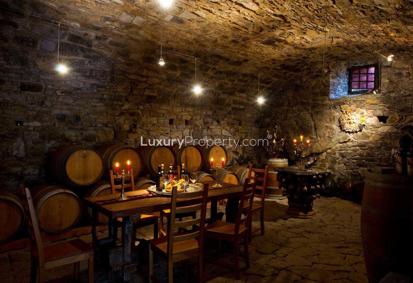Cozy living room in 16-bedroom Villa Panorama, Florence, featuring rustic wooden beams and fireplace