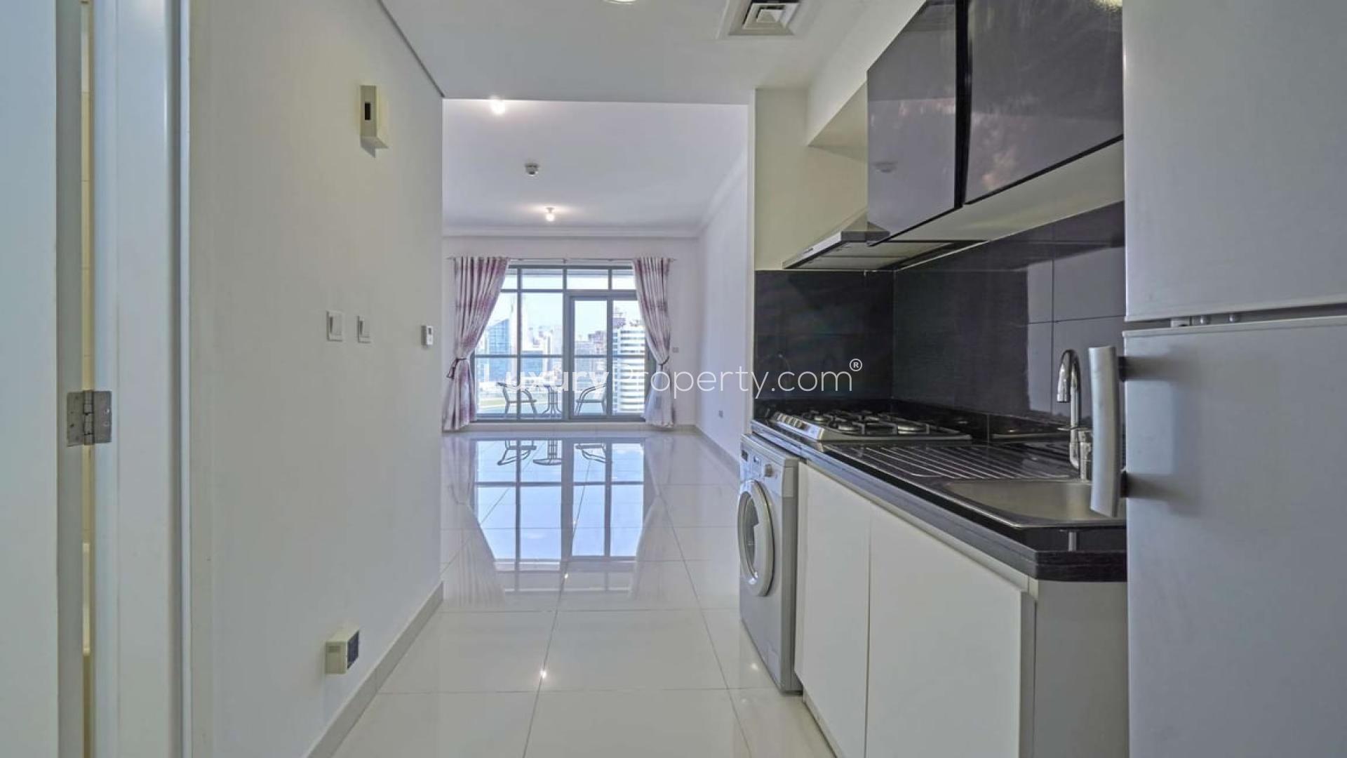 Studio apartment kitchen in Executive Bay, Business Bay, featuring modern appliances and sleek design