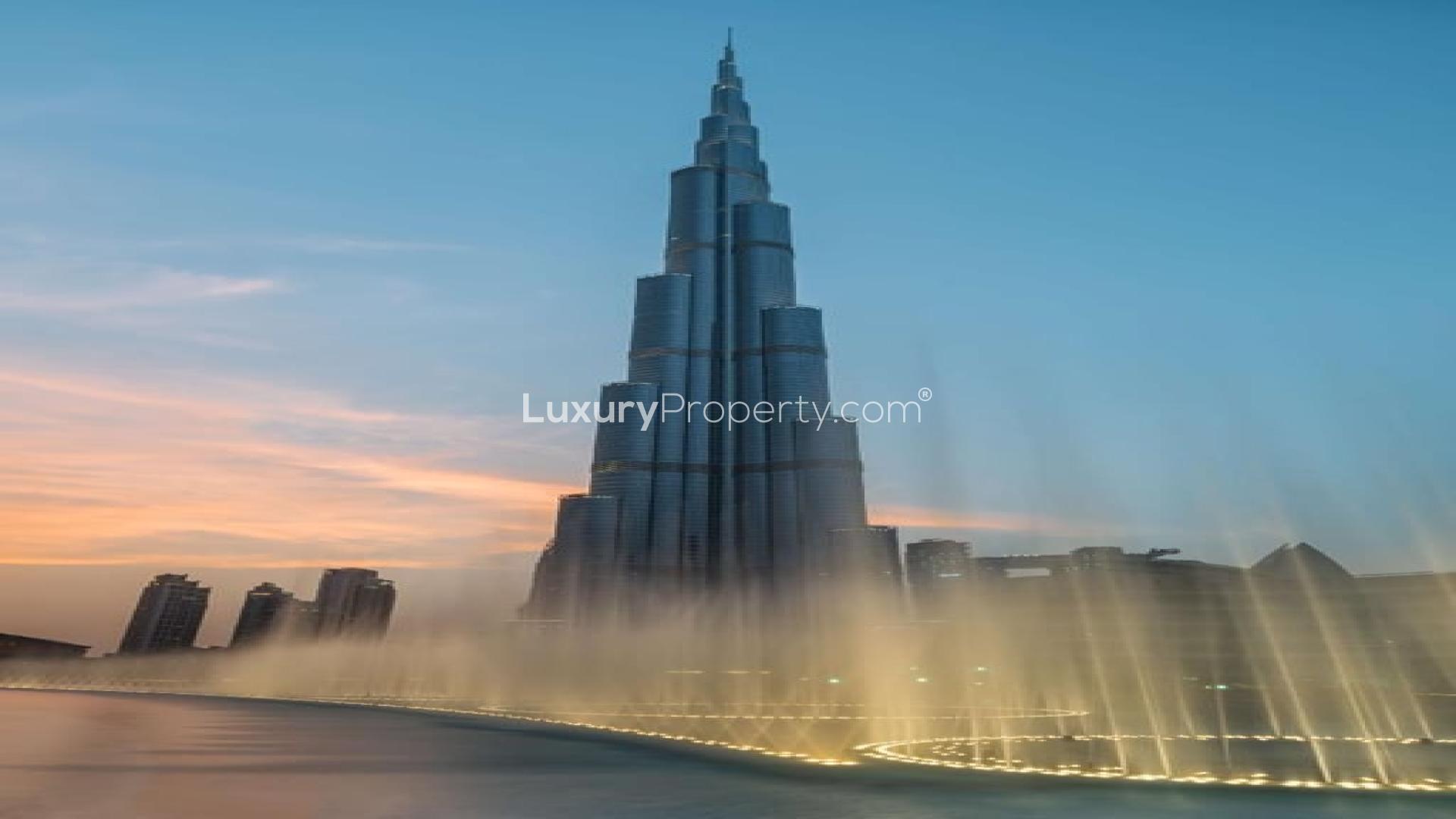 "Grande At The Opera District, Downtown Dubai waterfront view, luxury residential building for sale.",Alt text: "Grande At The Opera District, view of iconic building in Downtown Dubai at sunset.",Exterior view of Grande At The Opera District, Downtown Dubai, near waterfront walkway