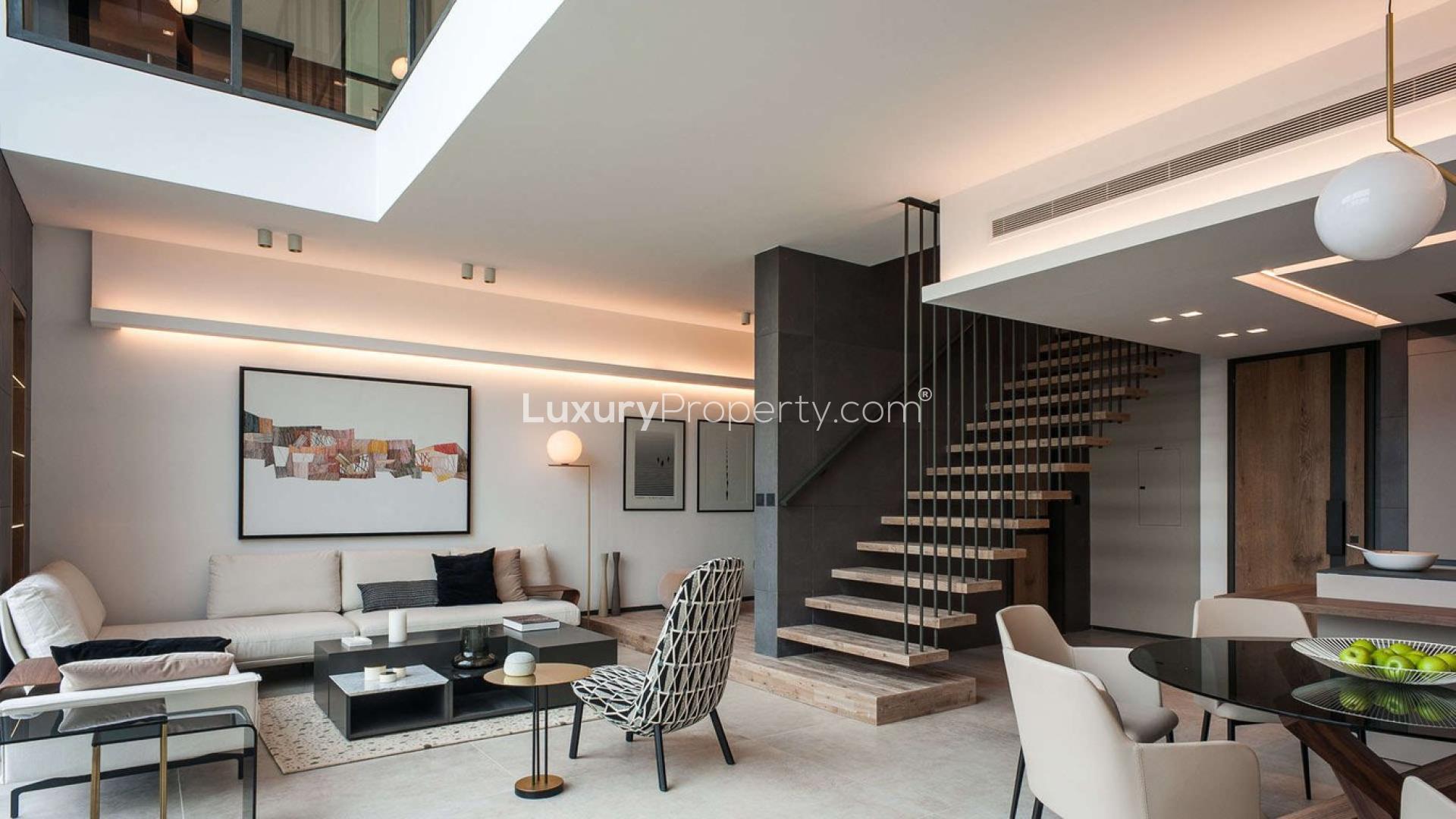 Modern studio apartment interior at The Terraces, MBR City, featuring open-plan kitchen and staircase