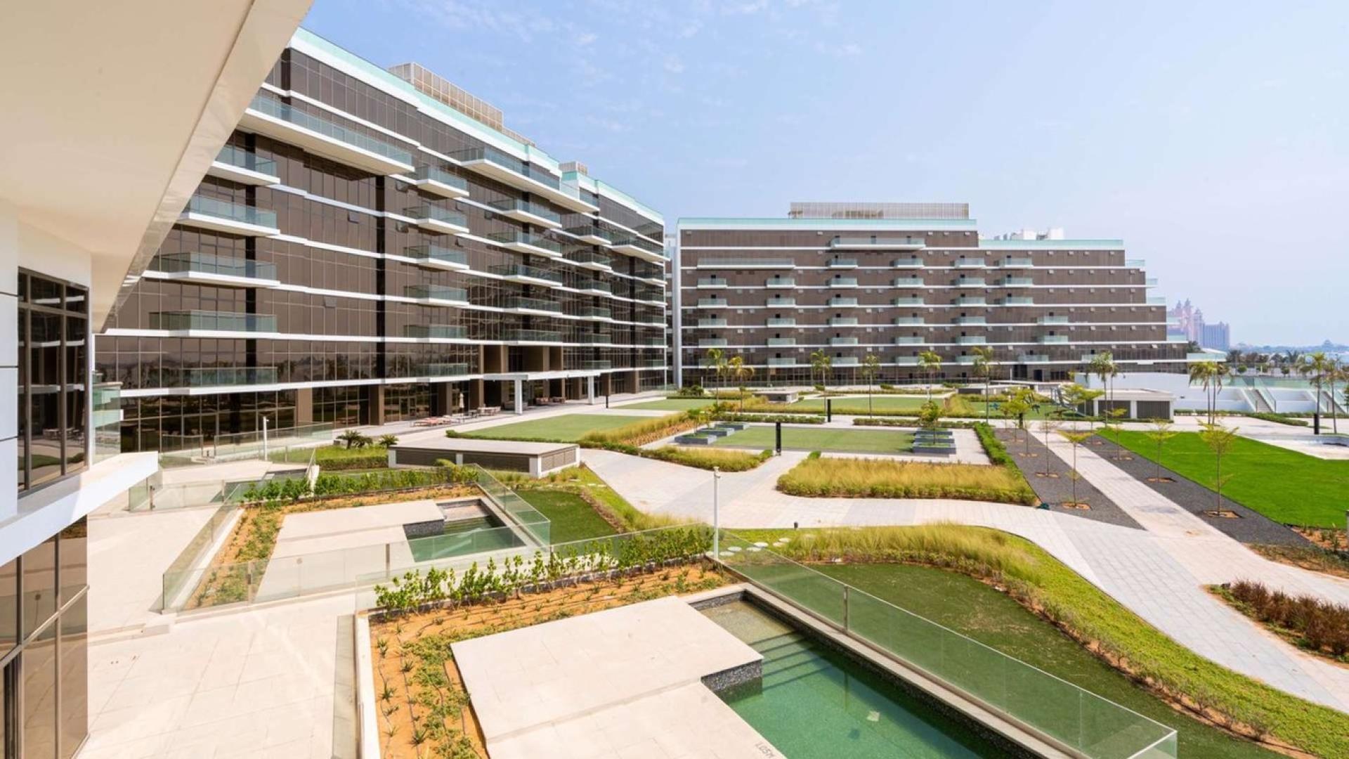Modern apartment exterior at The 8, Palm Jumeirah, with landscaped gardens