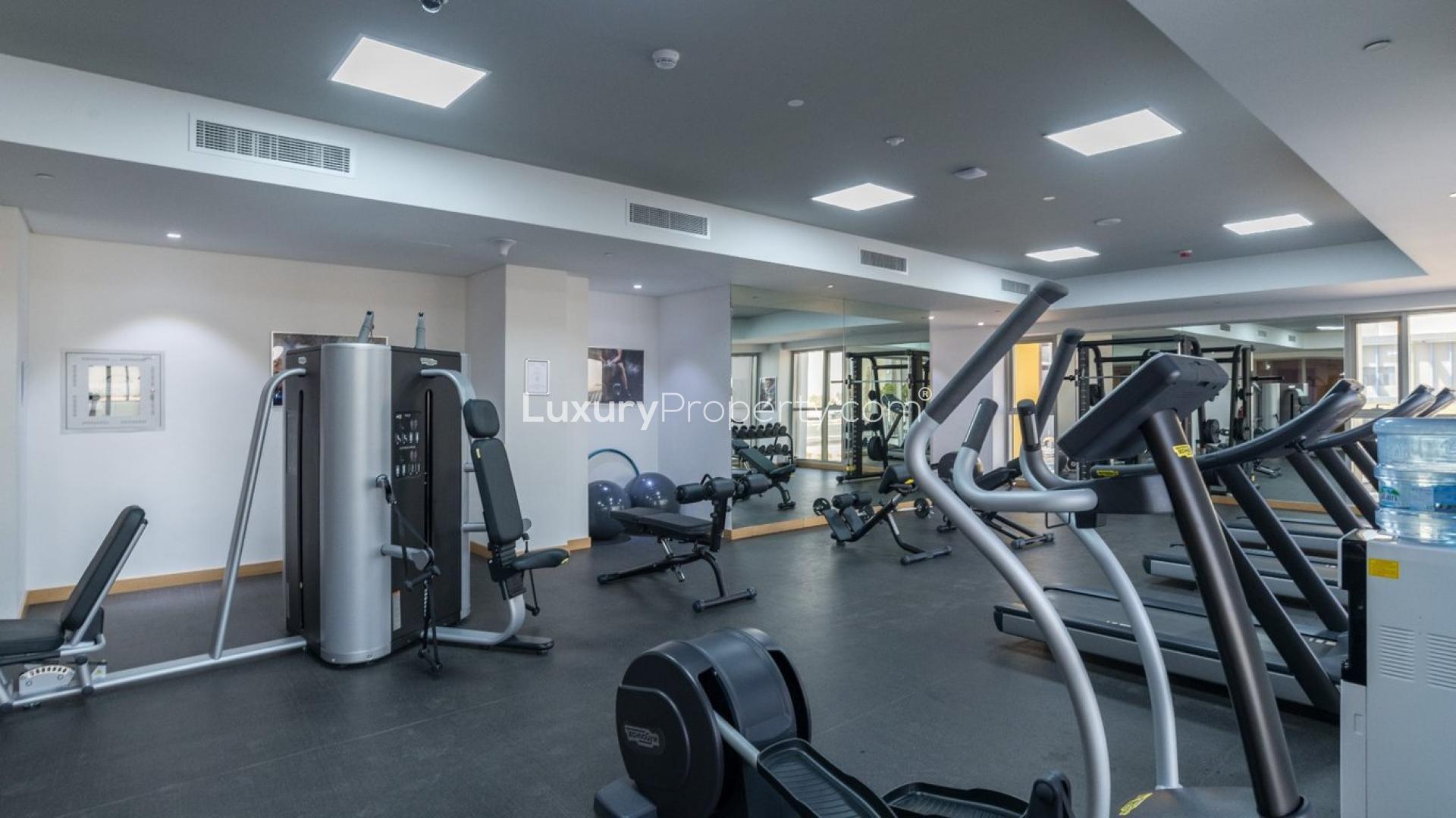 "Modern 130-unit apartment building for sale in Priva Living, Arjan community, Dubai.",Modern gym facility in Priva Living, Arjan apartment building with 130 units for sale