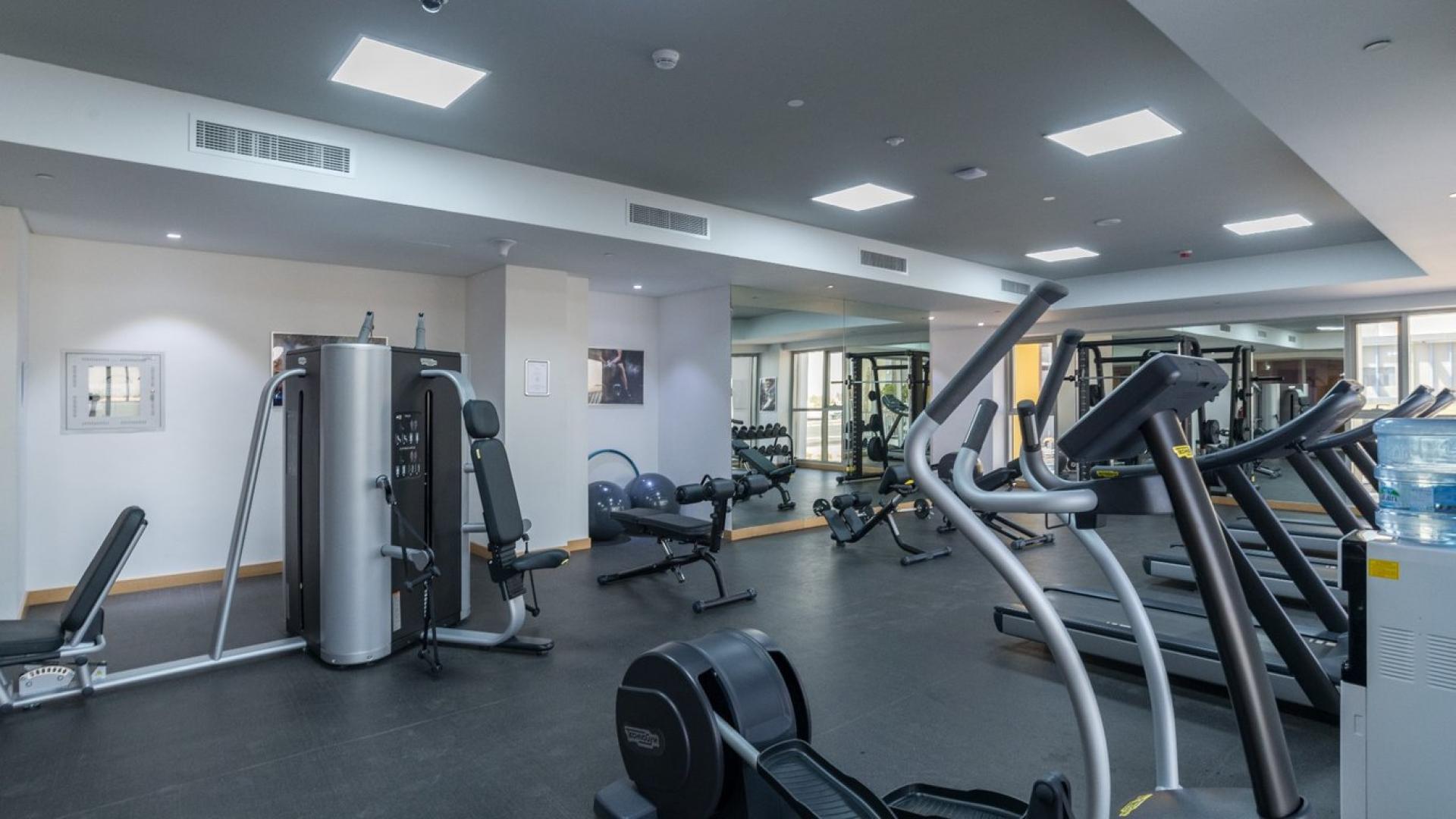 "Modern 130-unit apartment building for sale in Priva Living, Arjan community, Dubai.",Modern gym facility in Priva Living, Arjan apartment building with 130 units for sale