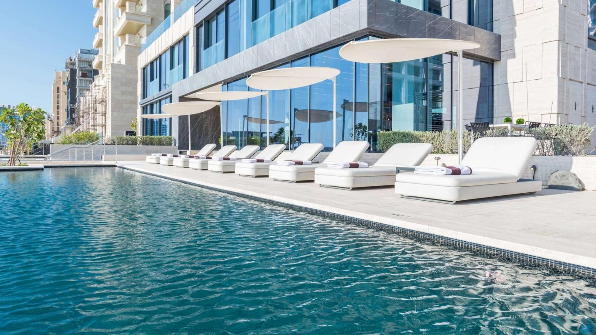 Luxury poolside lounge area at Palme Couture apartment, Palm Jumeirah, Dubai