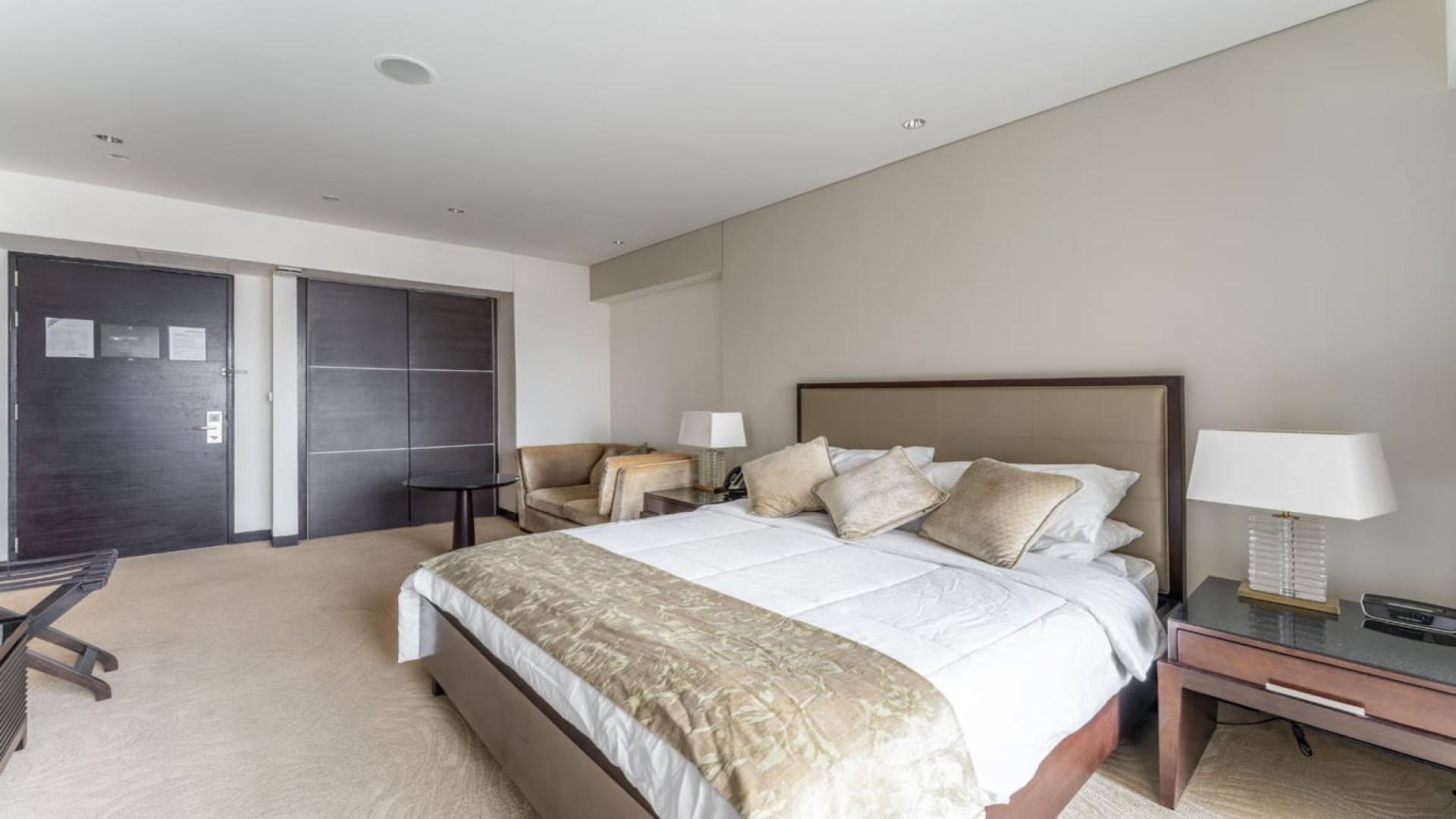 Furnished studio apartment interior in The Address Dubai Marina, with city view balcony