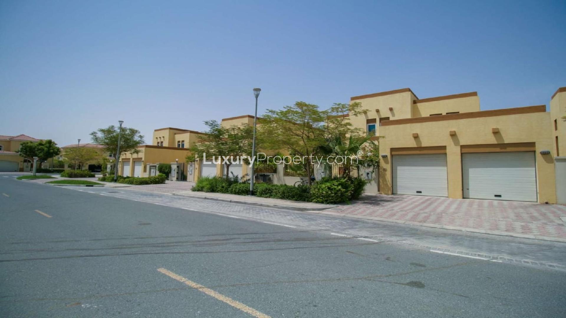 Street view of residential properties in Jumeirah Park, District 6, with garages and greenery