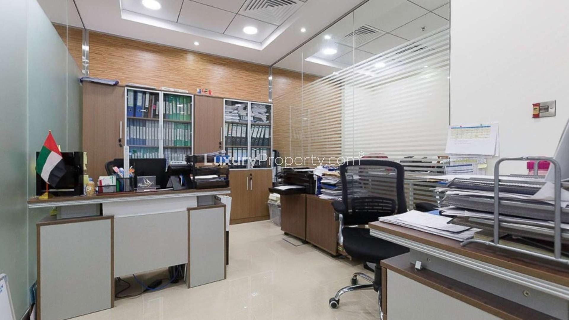 Fully furnished office lounge in Bay Square, Business Bay, featuring modern black leather sofas