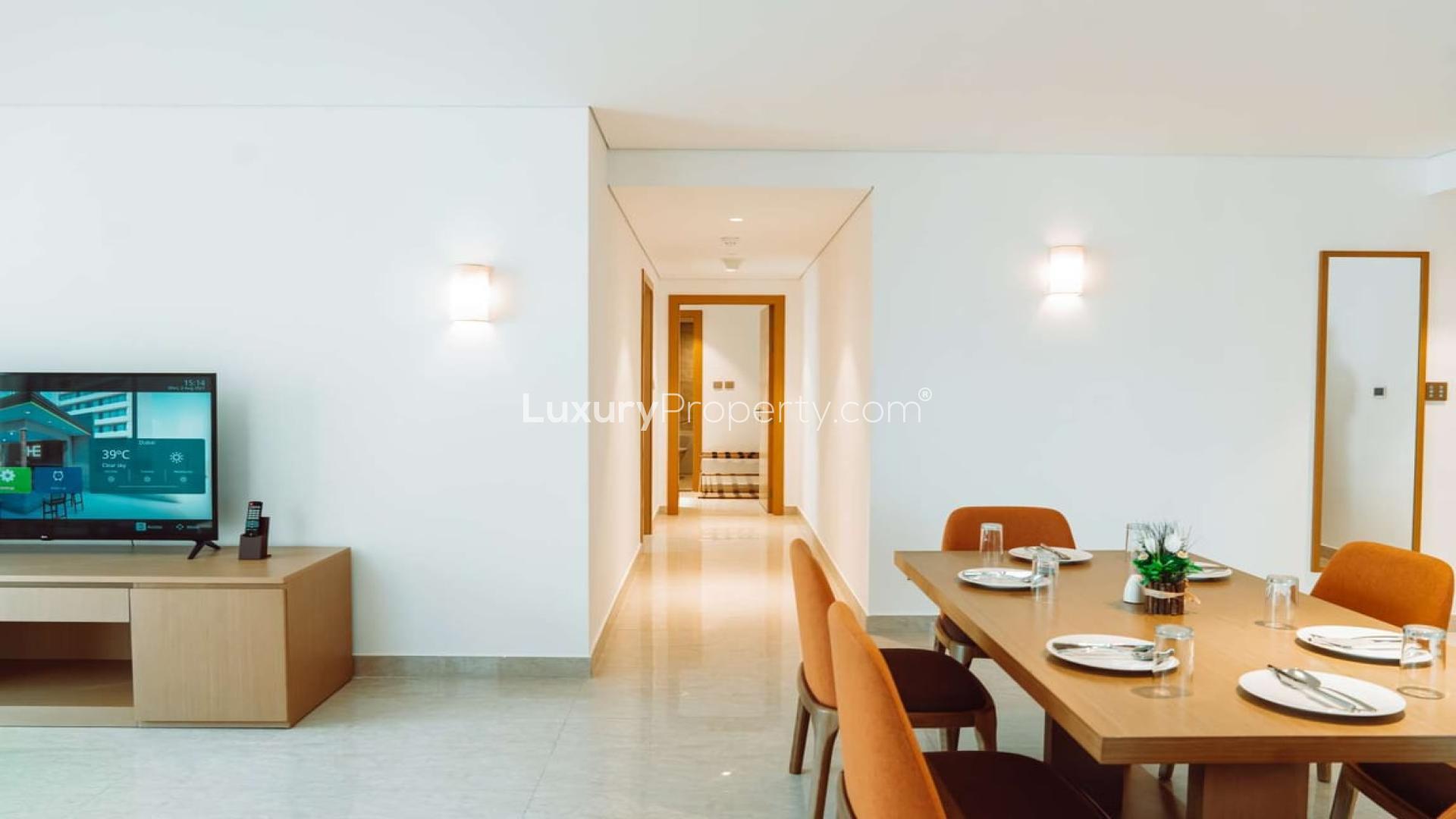 Studio apartment interior with modern decor, cozy bed, desk, and seating area for sale