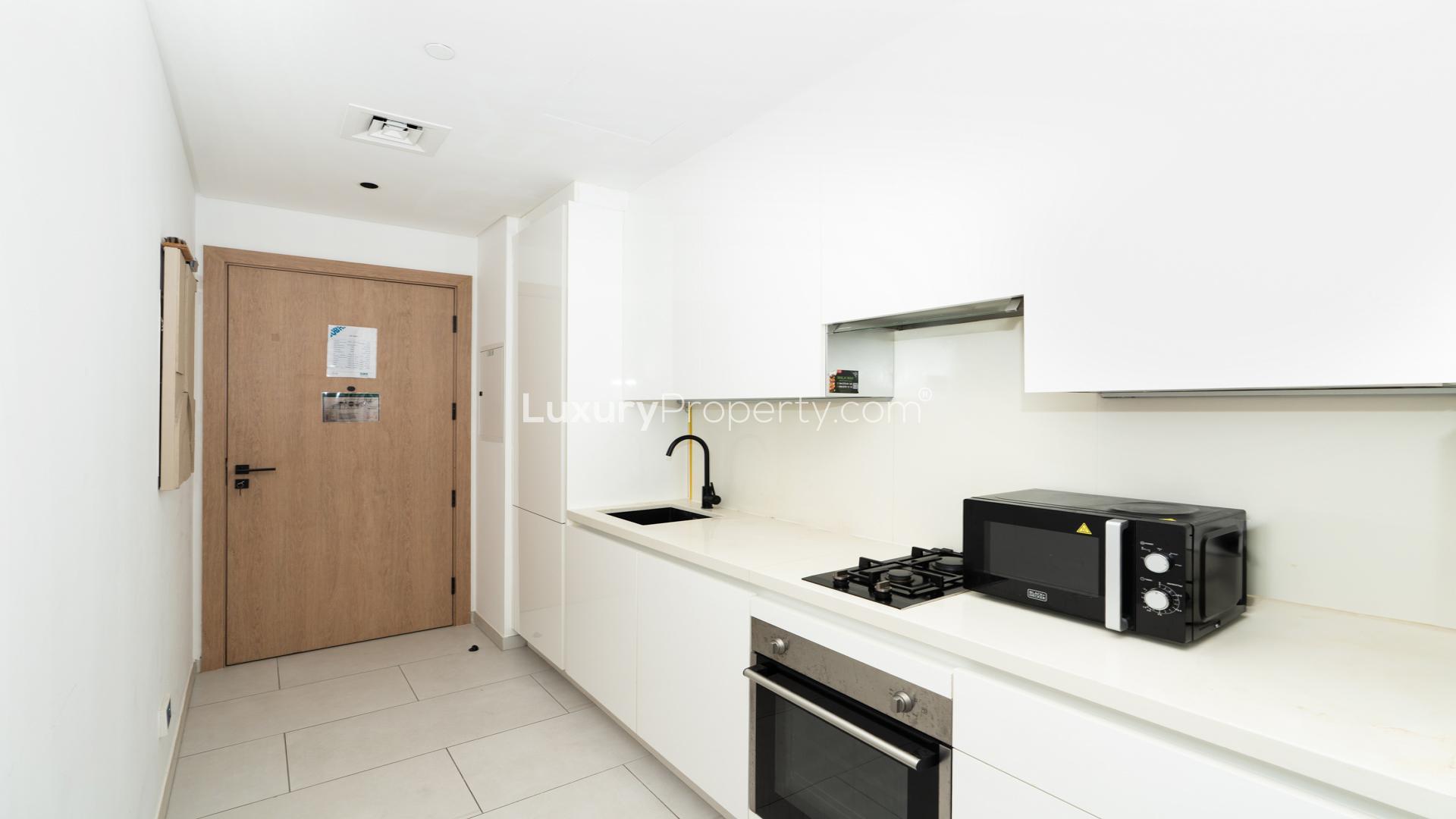 Furnished studio kitchen in Marquise Square Tower, Business Bay, with modern appliances and sleek design