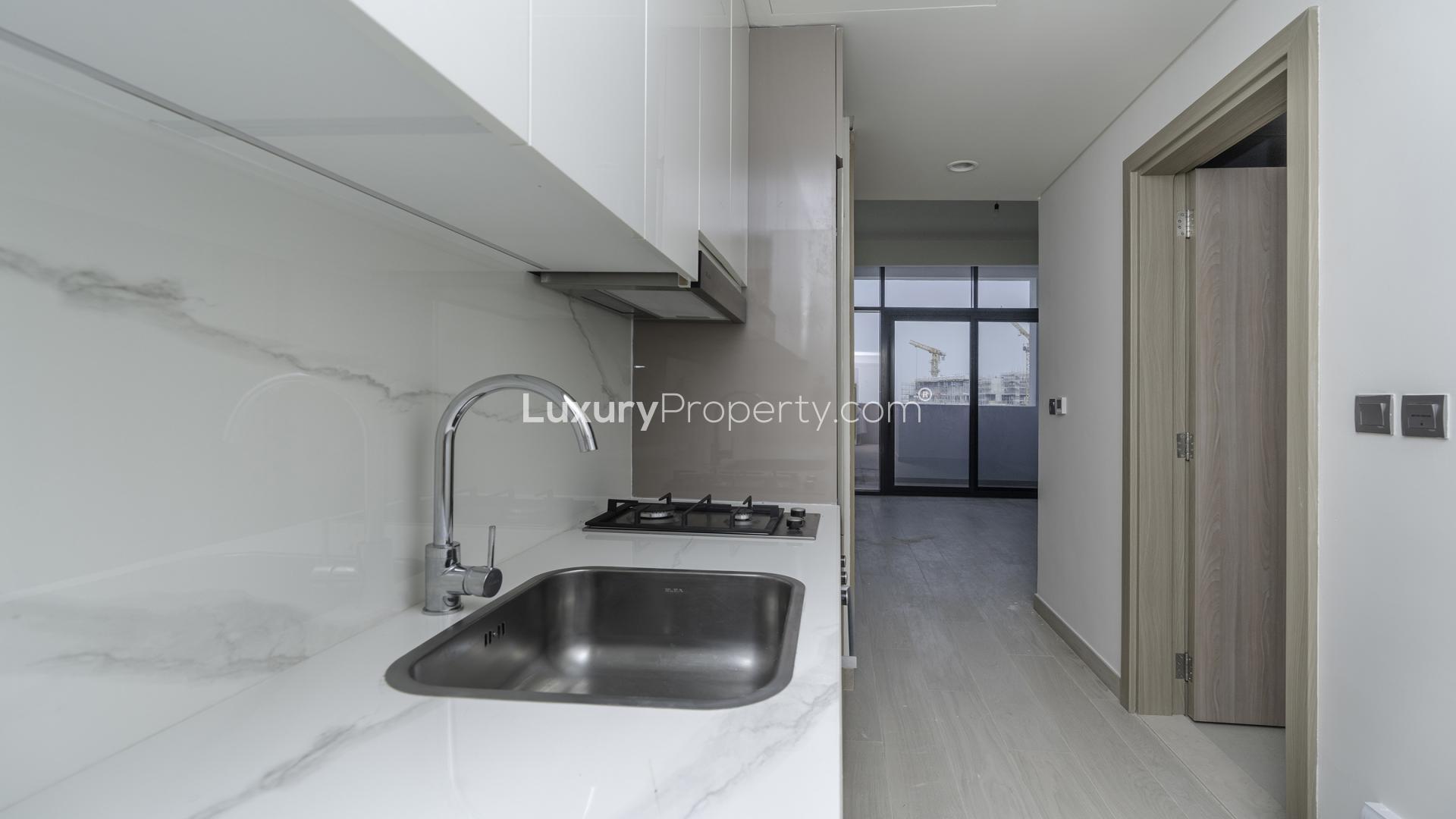 Modern Meydan One studio kitchen with sleek design and lagoon view balcony access