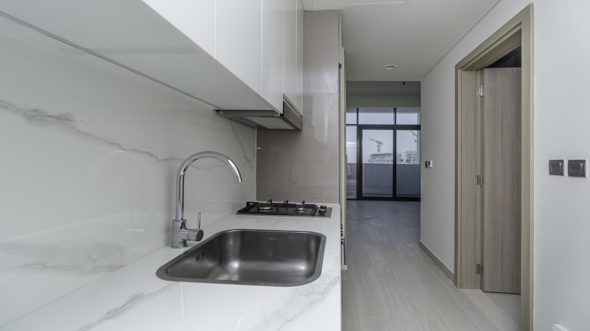 Modern Meydan One studio kitchen with sleek design and lagoon view balcony access