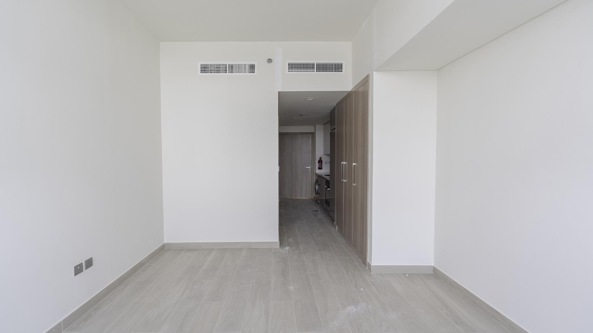 Modern studio apartment with large windows in Meydan One, offering lagoon views